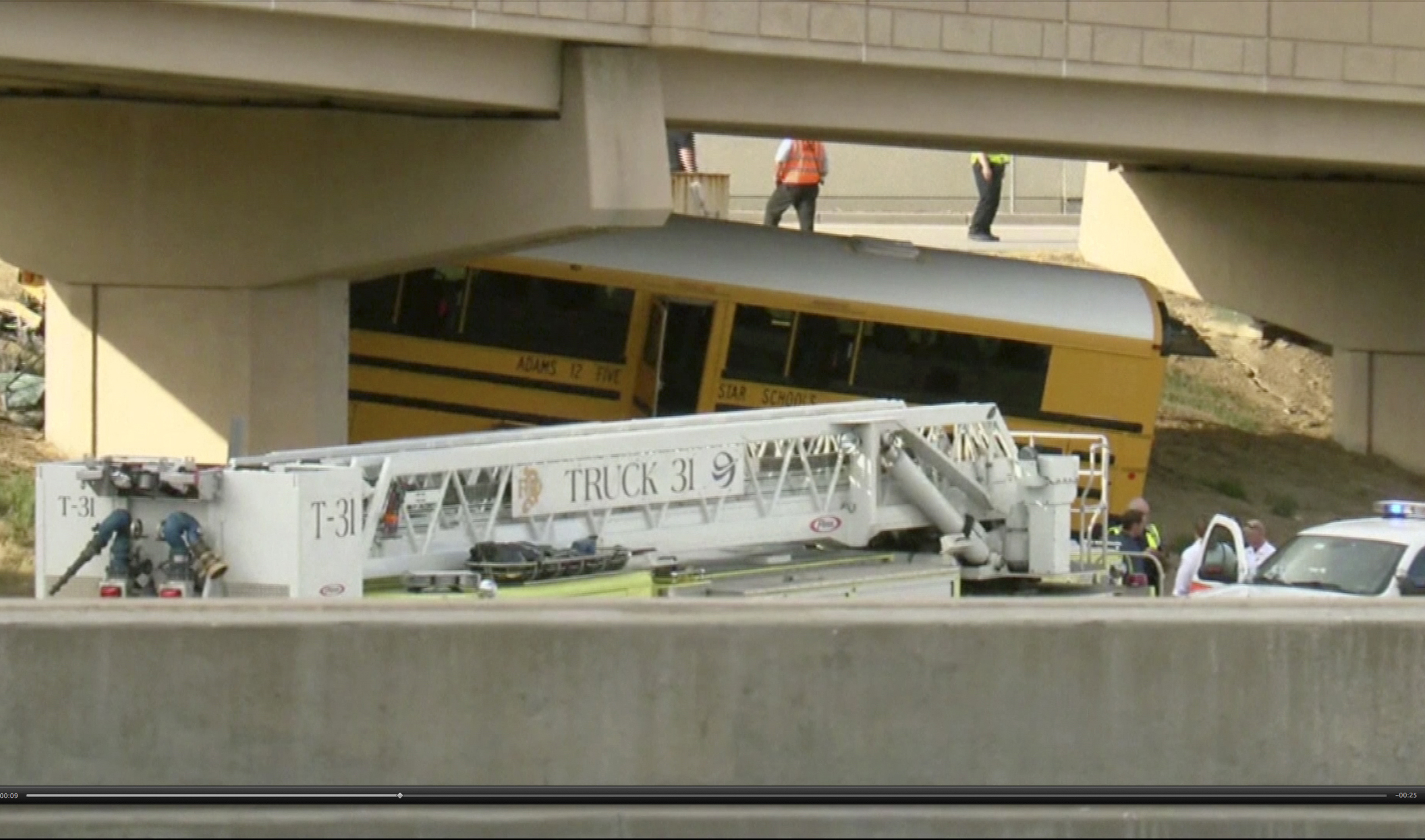 Emergency personnel stand near the scene of a school bus that crashed into a concrete pillar in Denver, on Sept. 11, 2016.