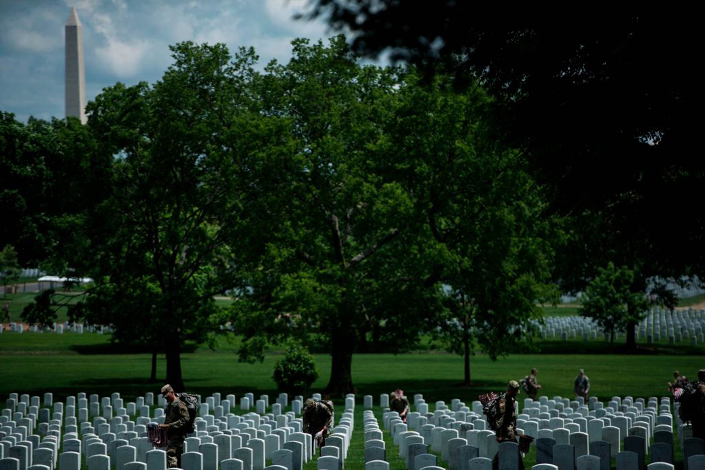 Soldiers in the Old Guard place flags at graves in Arlington National Cemetery during "Flags In" in preparation for Memorial Day May 25, 2017, in Arlington, Virginia.