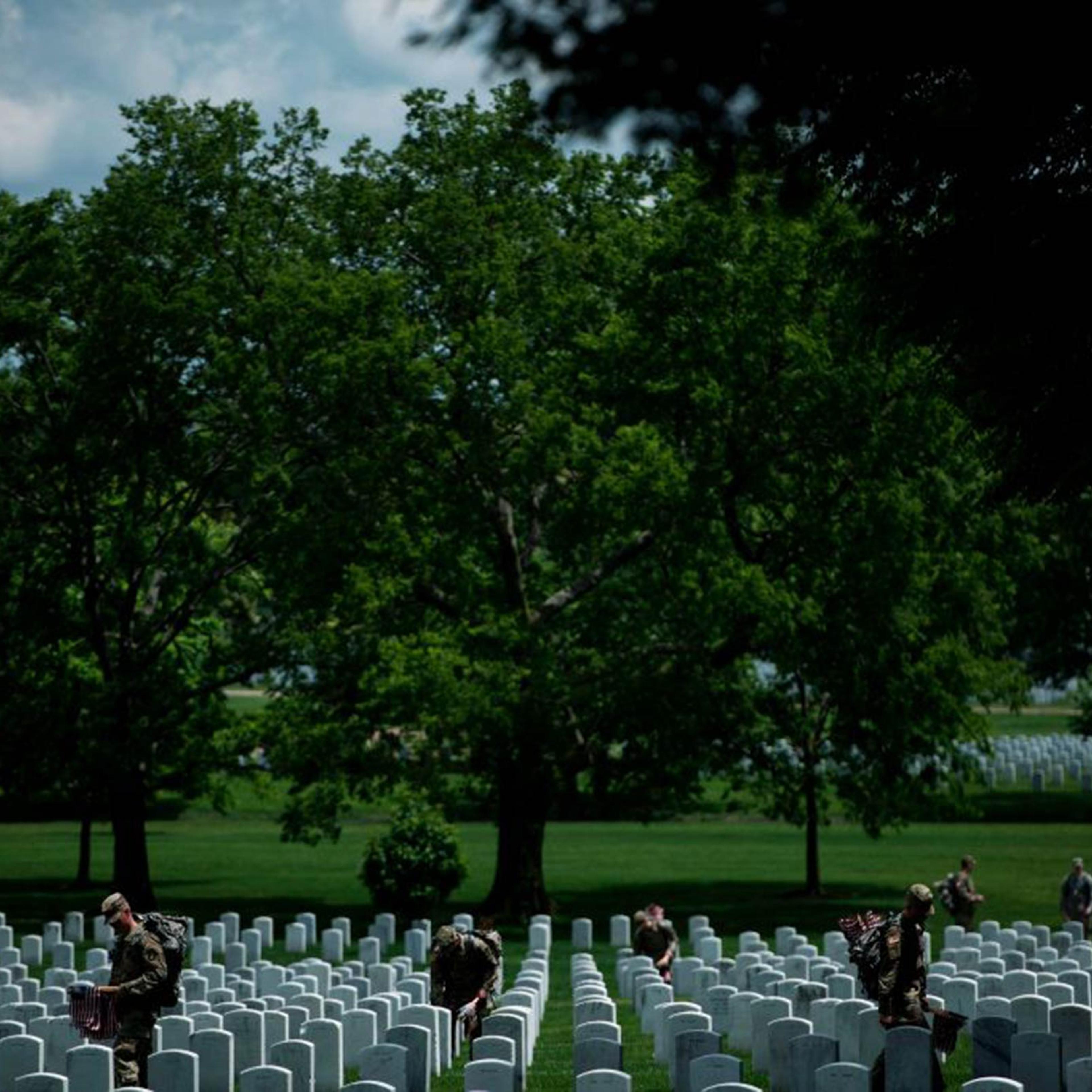 Soldiers in the Old Guard place flags at graves in Arlington National Cemetery during "Flags In" in preparation for Memorial Day May 25, 2017, in Arlington, Virginia.