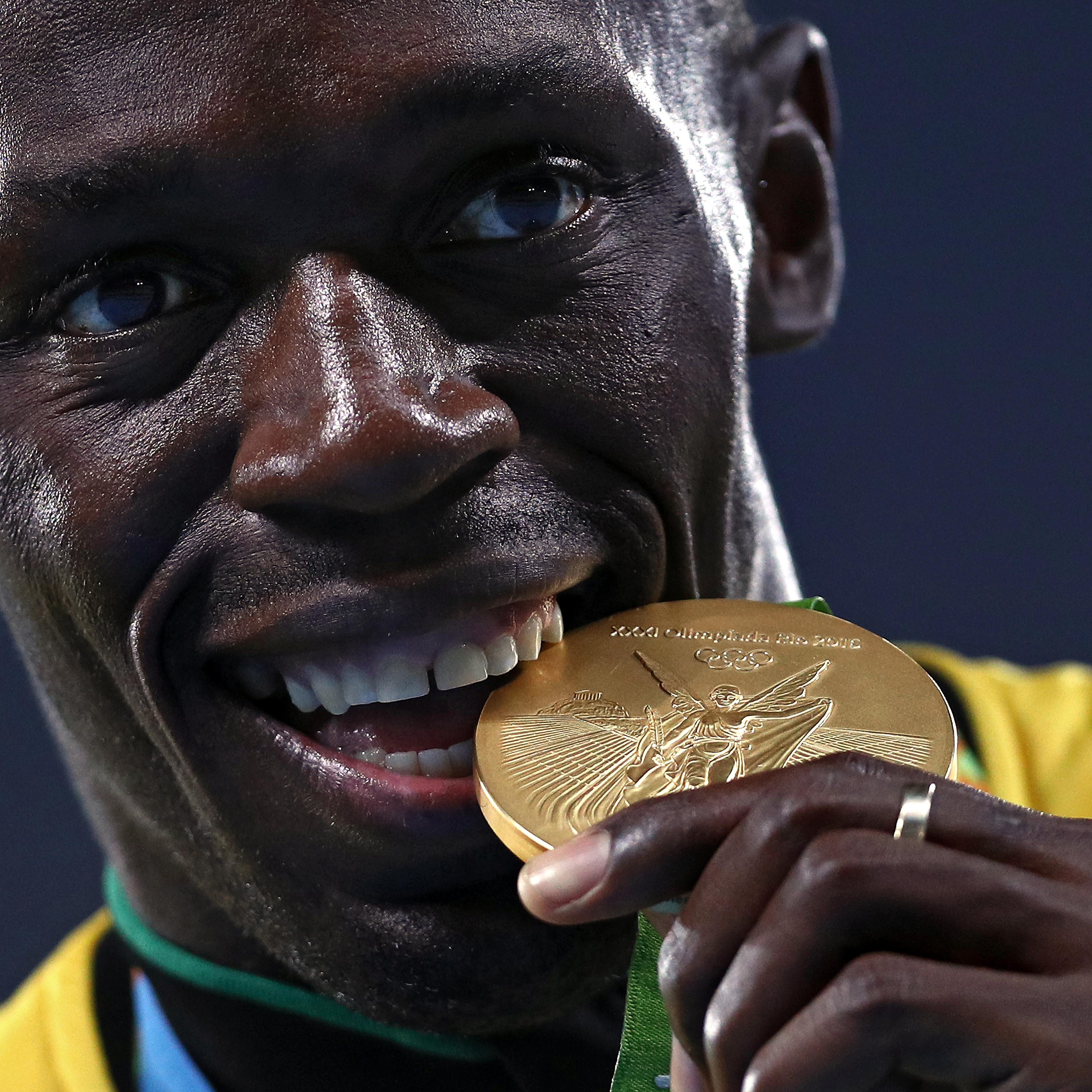 Usain Bolt bites his gold medal during the medal ceremony for the Men's 4 x 100 meter Relay on Day 15 of the Rio 2016 Olympic Games at the Olympic Stadium on Aug. 20, 2016 in Rio de Janeiro.