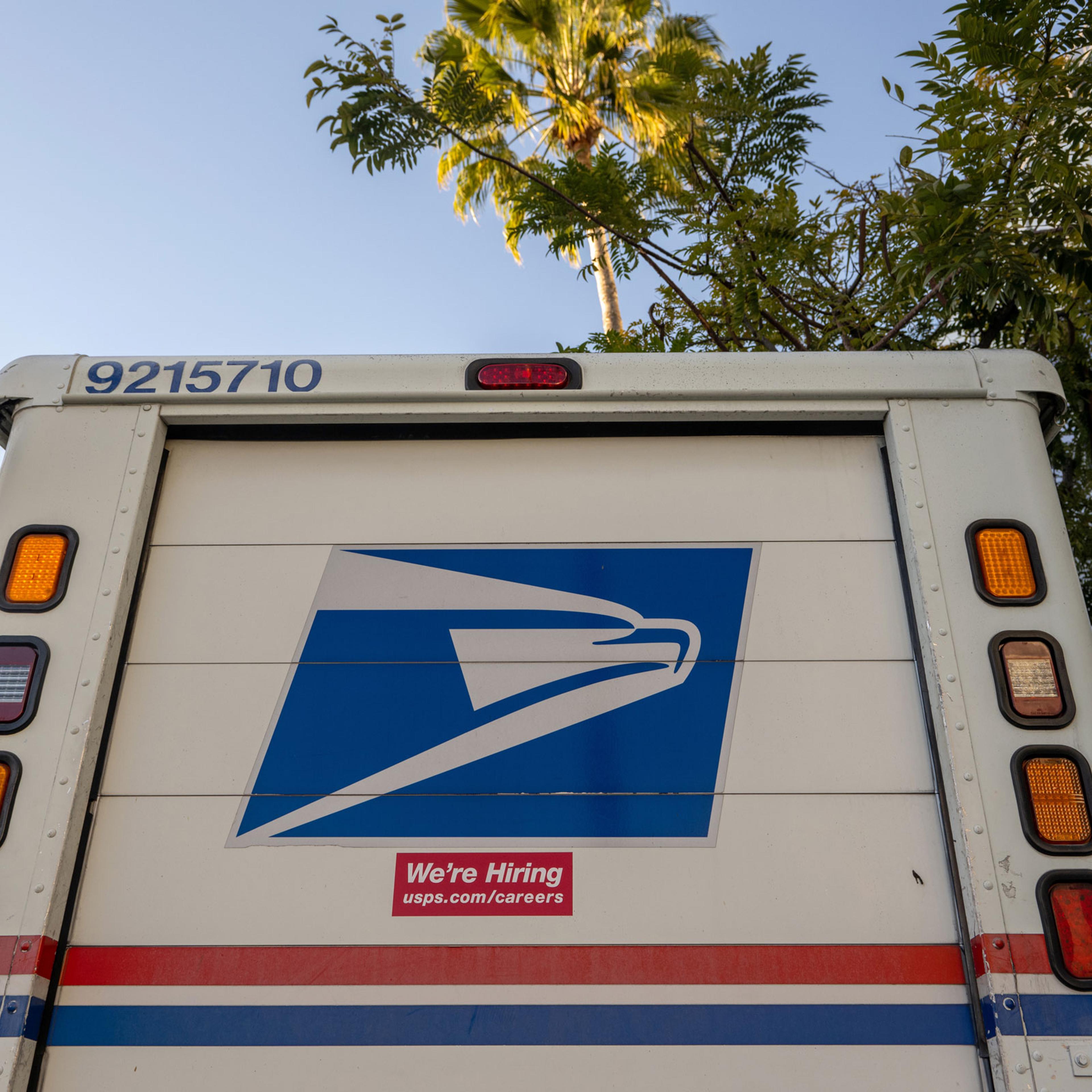 A "We're Hiring" sticker is displayed on a USPS postal truck in Beverly Hills