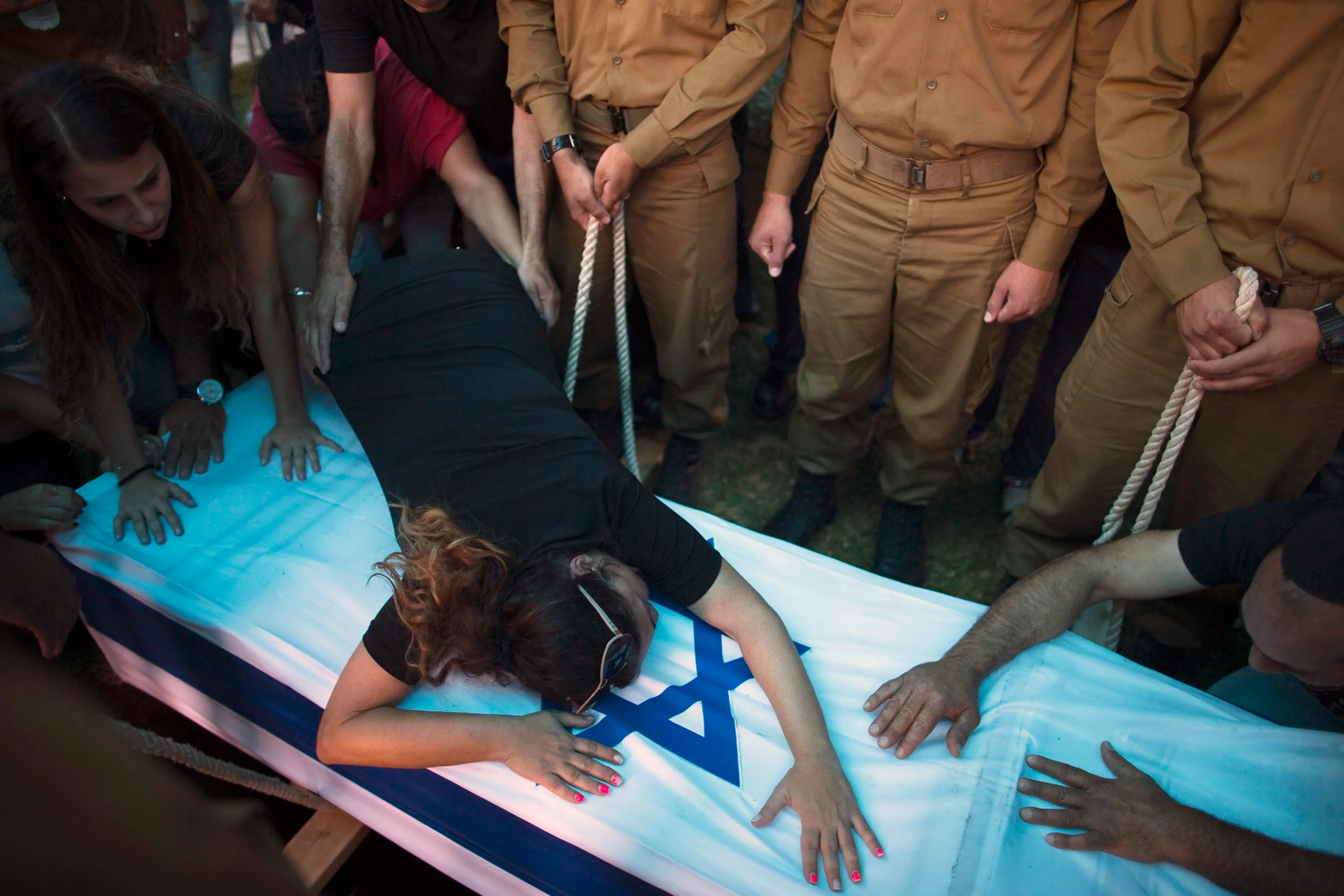 The mother of Israeli soldier Tal Yifrah mourns over his flag-covered coffin during his funeral in Rishon Lezion near Tel Aviv, July 22, 2014.