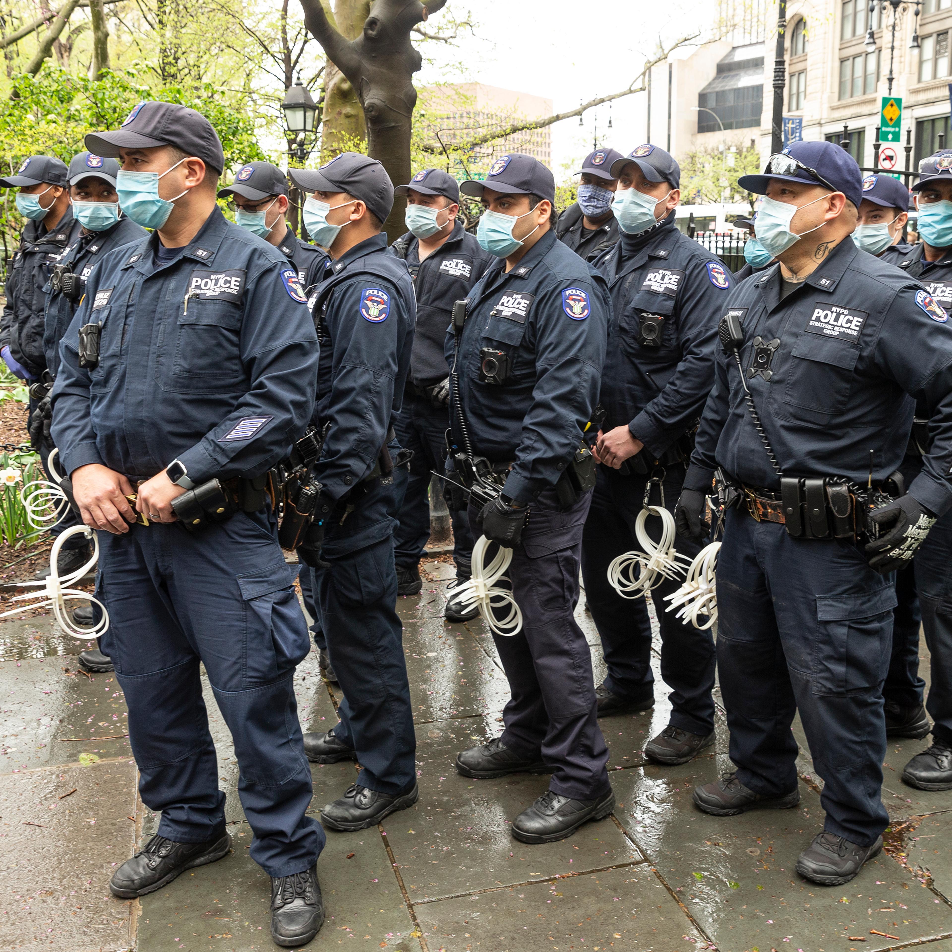 Police officers watching as activists hold small Make