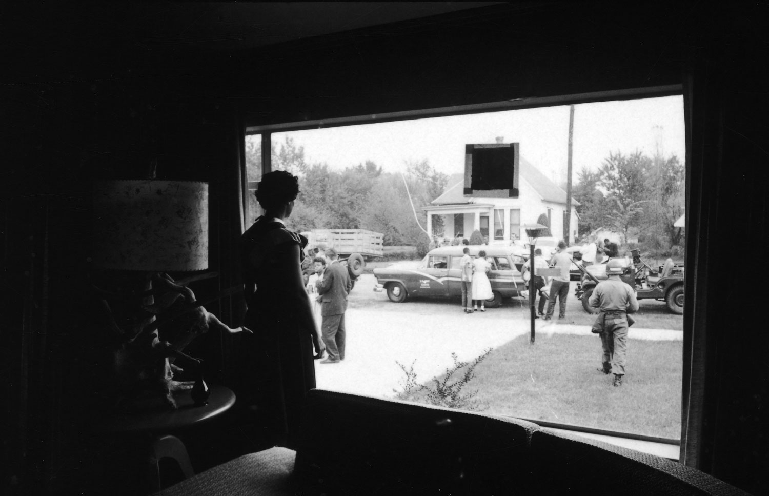 Civil Rights leader Daisy Bates gazes through her front window, watching the U.S. Army's 101st Airborne Division escort the Little Rock Nine from her home to begin their first full day of classes at the formerly all-white Central High School in Little Ro