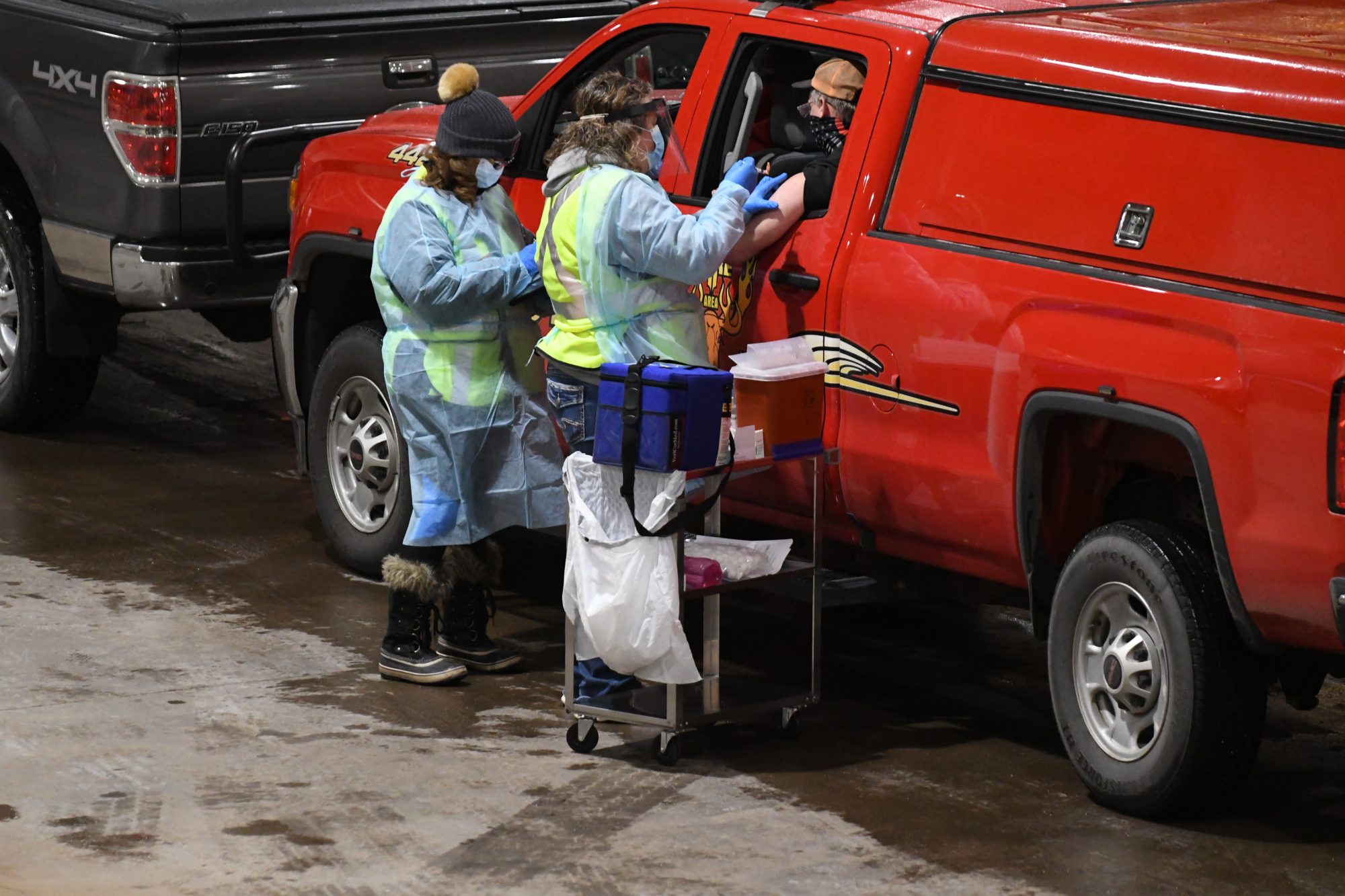 A fire fighter receives a COVID-19 vaccine shot on day one of Carlton County's drive-through vaccination clinic