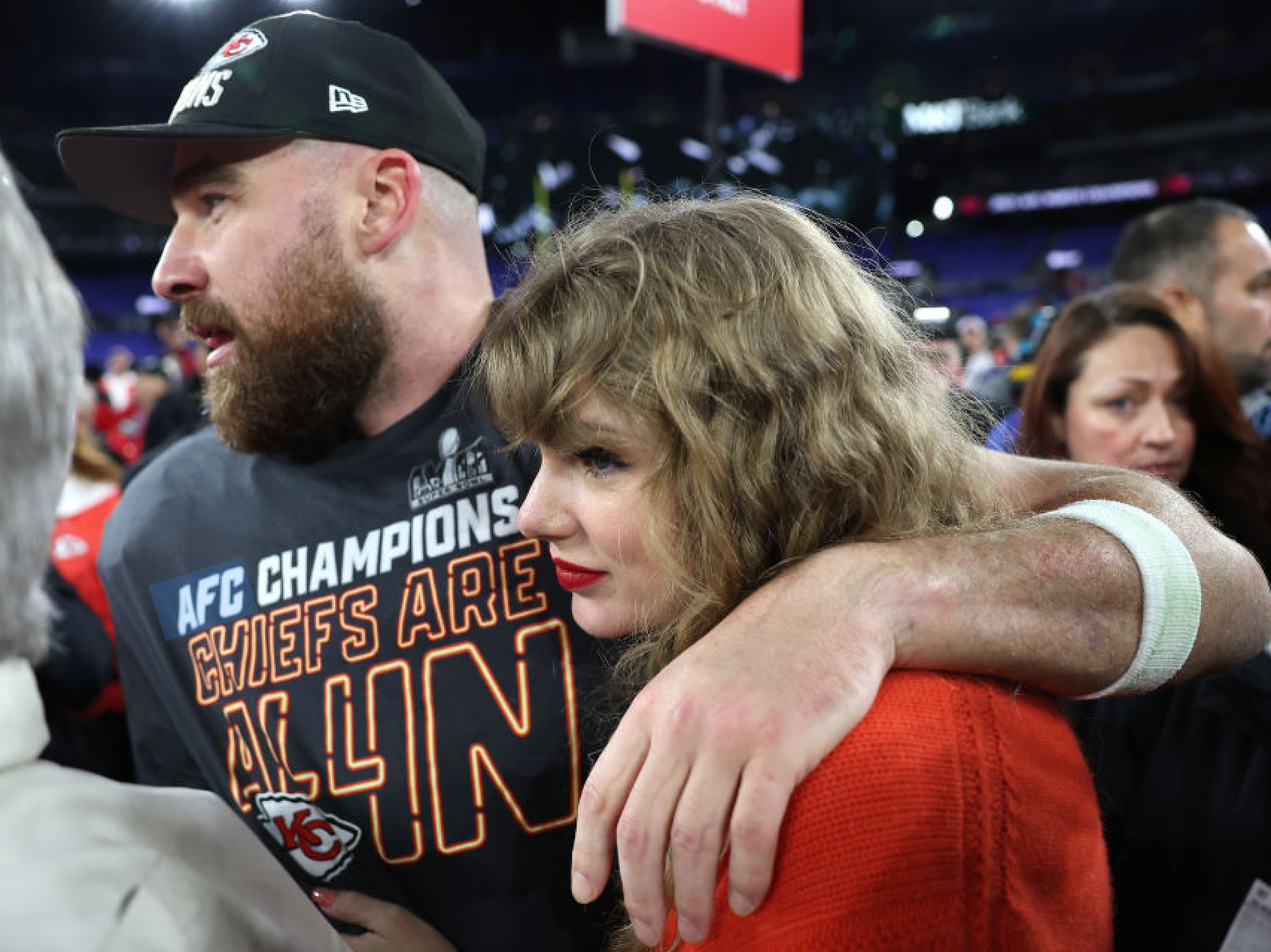 Taylor Swift and Travis Kelce, seen here on the field after an NFL game in Jan. 2024, have each donated $100,000 to victims of the Kansas City Chiefs Super Bowl parade shooting.