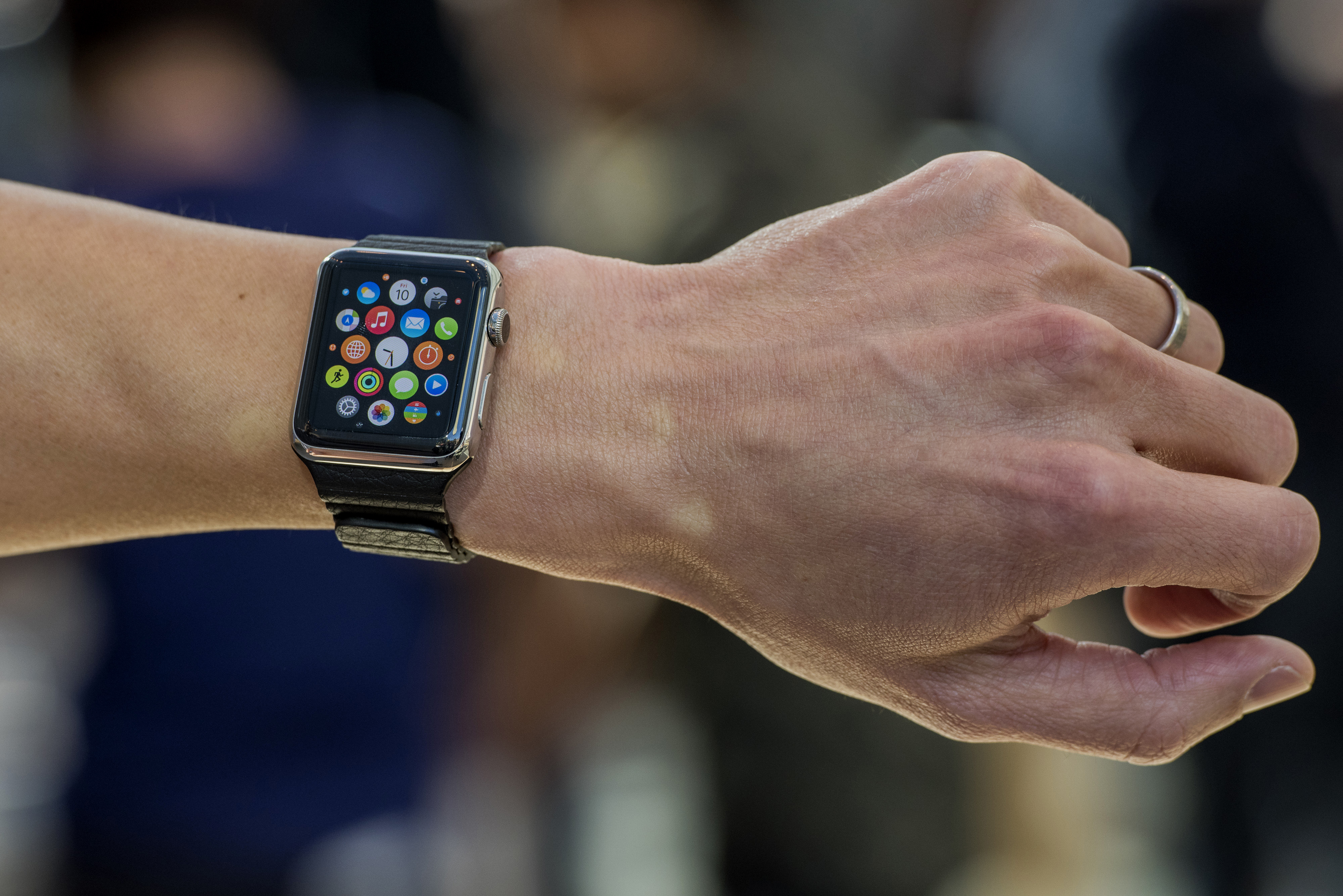 Customers look at Apple Watches on display at an Apple Inc. store in Palo Alto, California, U.S., on Friday, April 10, 2015. From London to Beijing, Apple stores saw few customers lined up before opening Friday as pre-orders started. The first new gadget