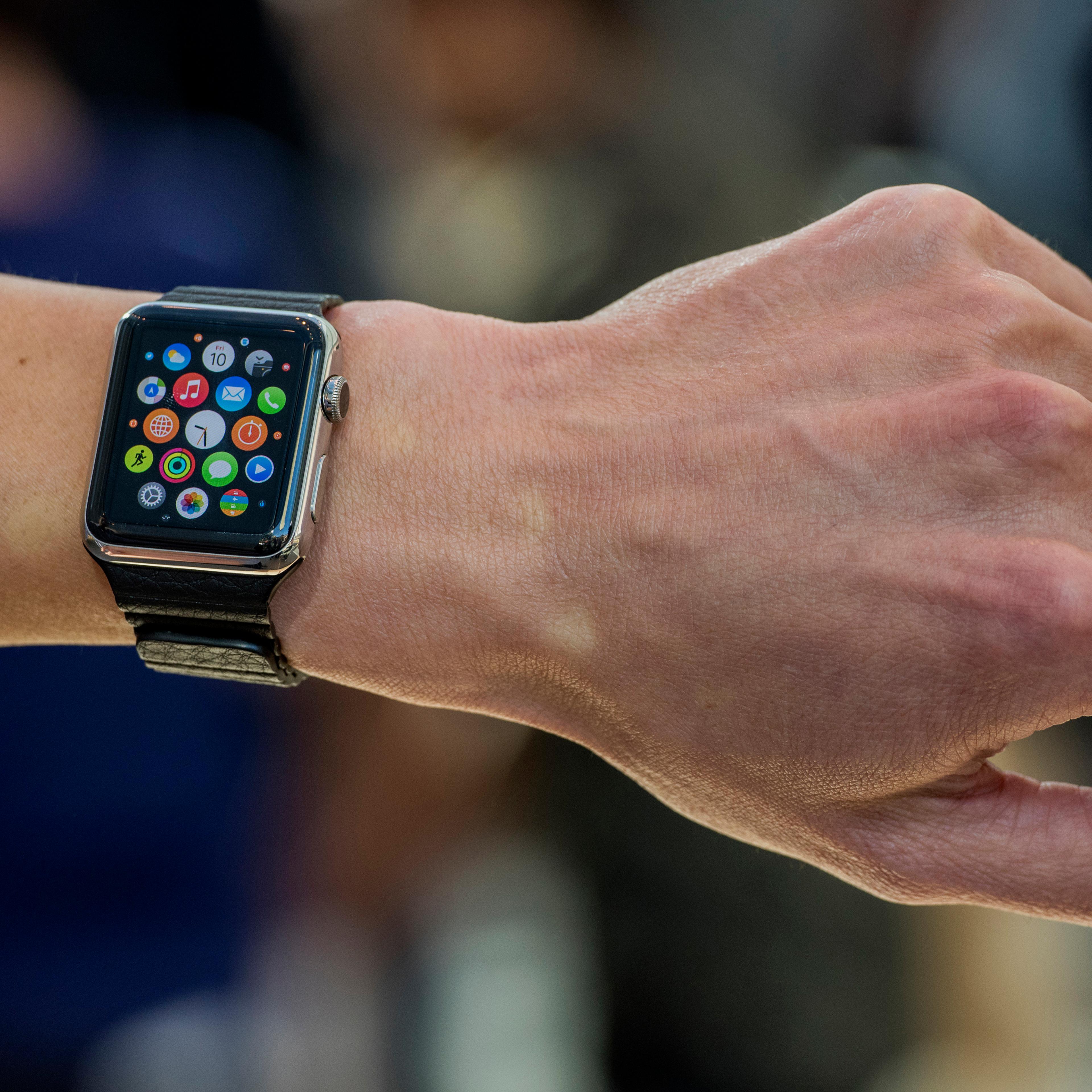 Customers look at Apple Watches on display at an Apple Inc. store in Palo Alto, California, U.S., on Friday, April 10, 2015. From London to Beijing, Apple stores saw few customers lined up before opening Friday as pre-orders started. The first new gadget