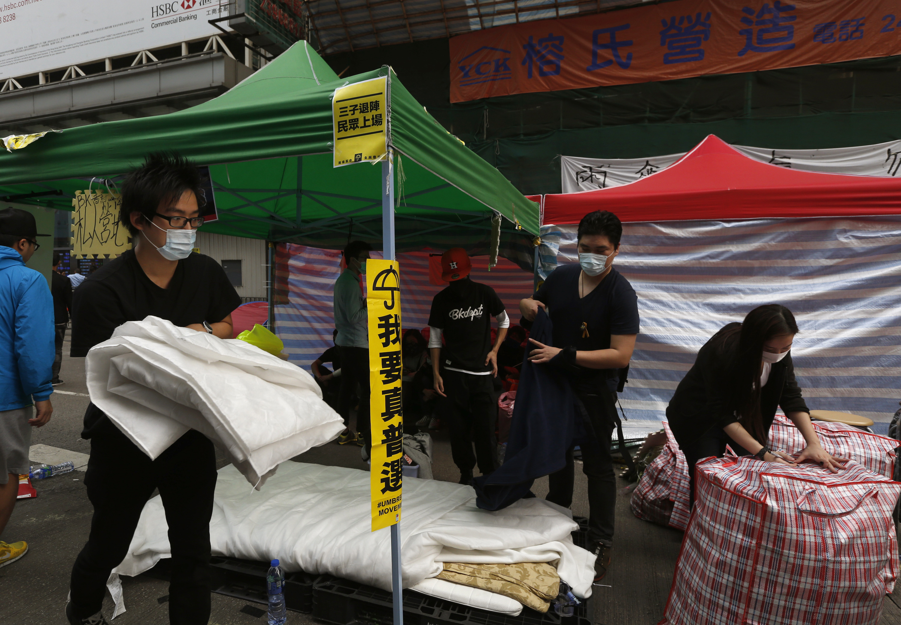 Masked pro-democracy protesters pack their belongings, before they are removed by bailiffs under a court injunction, at Mong Kok shopping district in Hong Kong