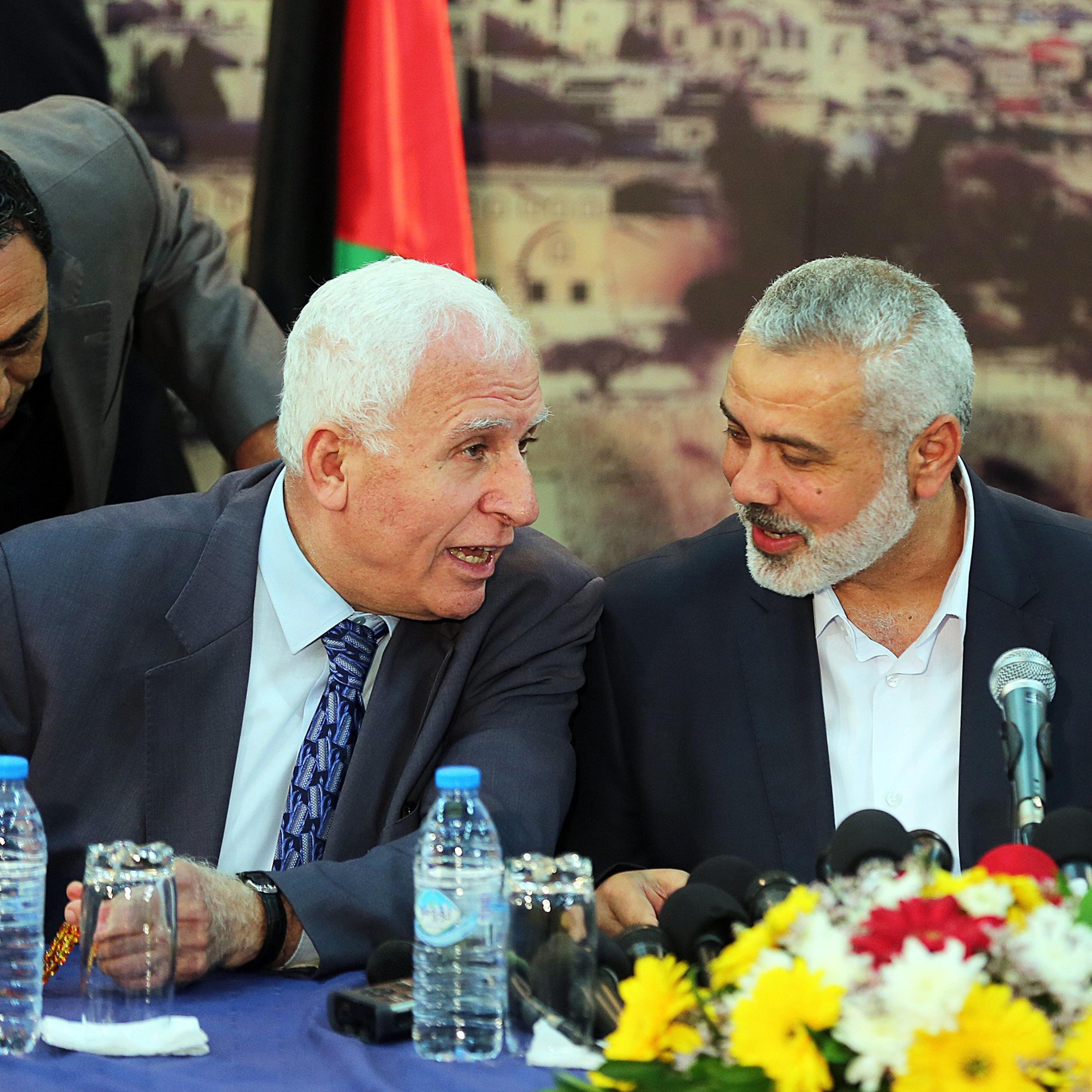 From left: Fatah movement Leader Azzam Al-Ahmad and Palestinian Prime Minister Ismail Haniyeh speak during a press conference following the meeting to end Palestinian divisions between Fatah and Hamas movement in Gaza City on April 23, 2014.