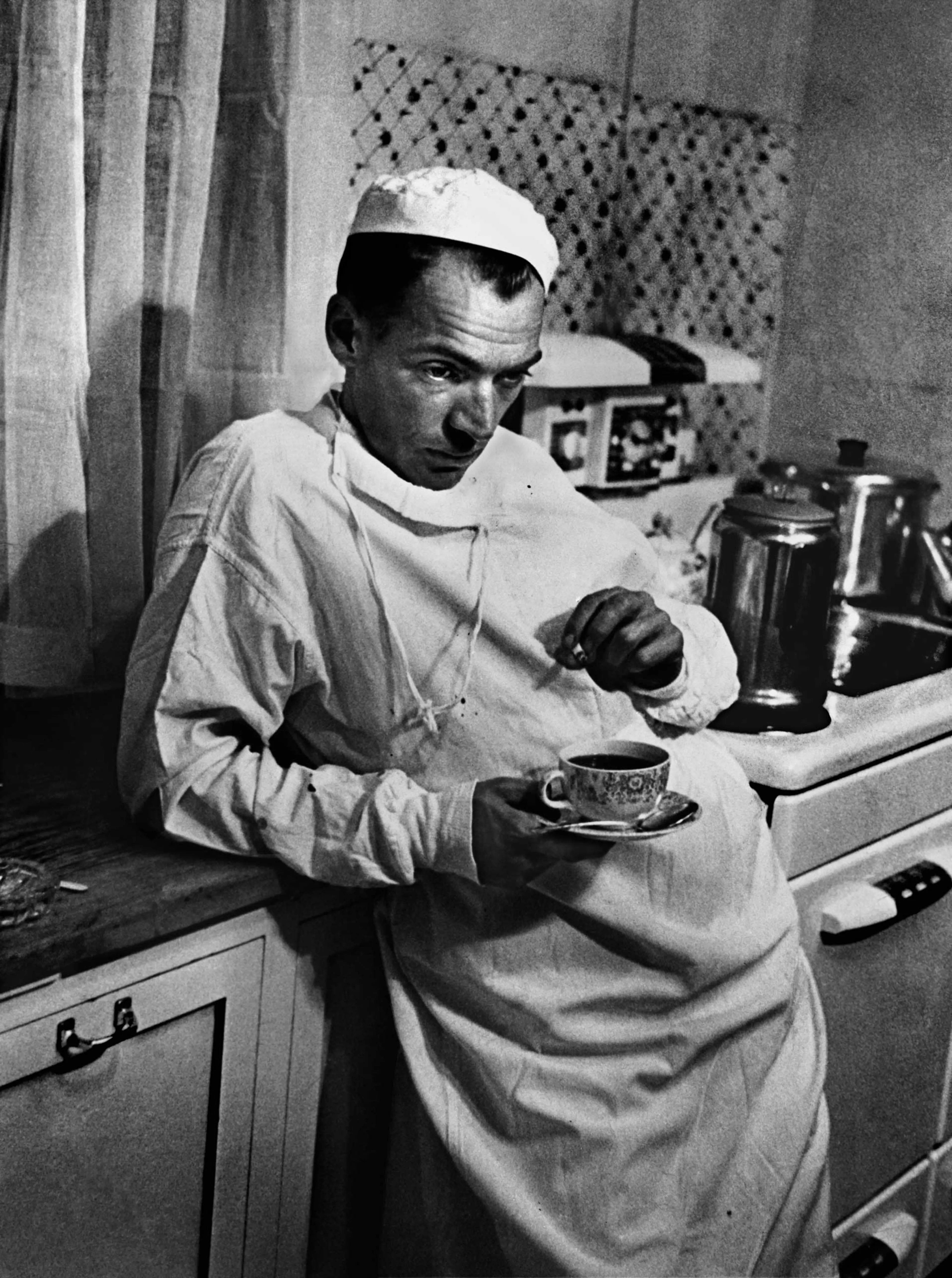 Dr. Ernest Ceriani, a general practitioner in tiny Kremmling, Colorado, stands in the town's hospital kitchen after a surgery that lasted until 2 AM. This was the final image in W. Eugene Smith's groundbreaking photo essay, "Country Doctor," originally p
