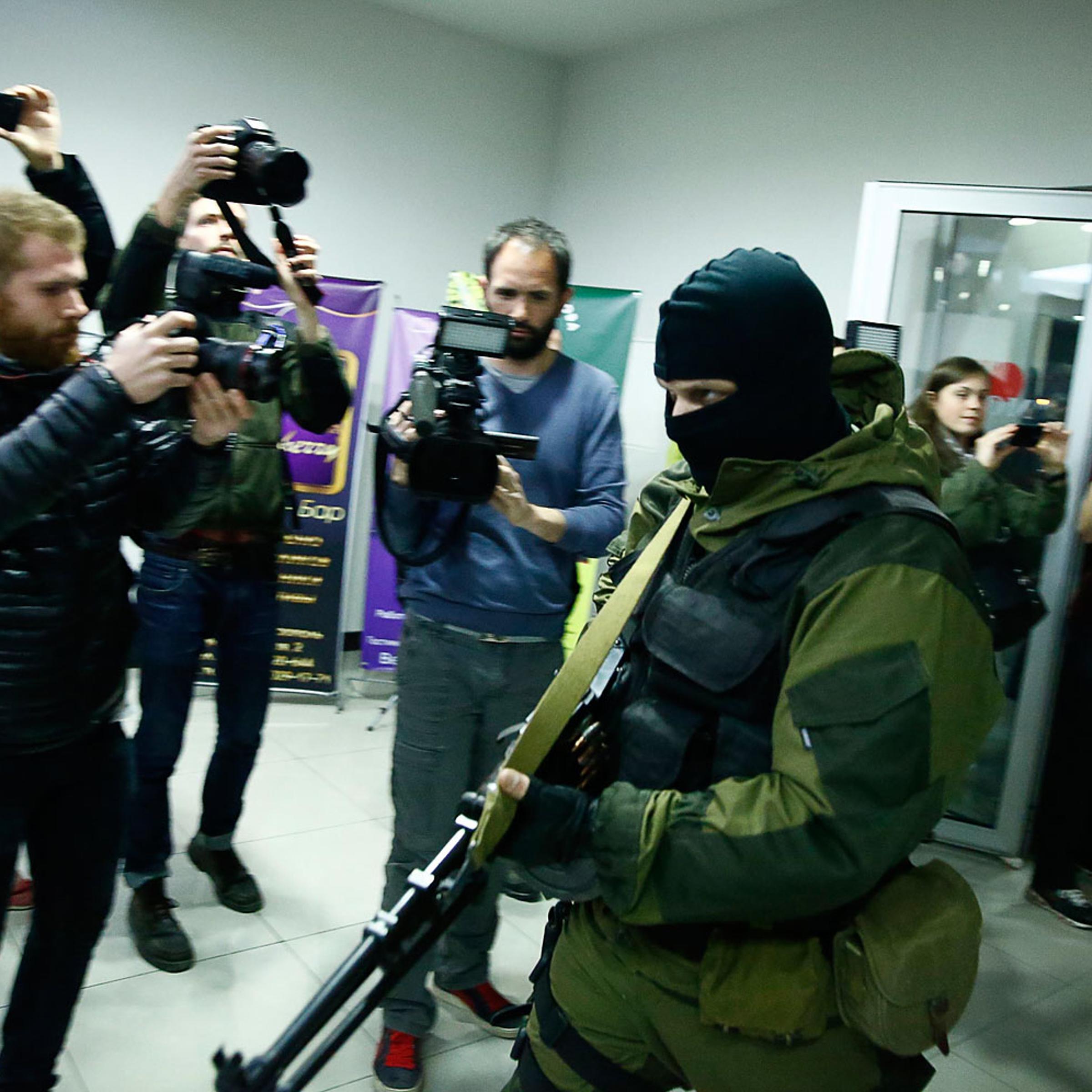 An armed man leaves the Moscow hotel in Simferopol