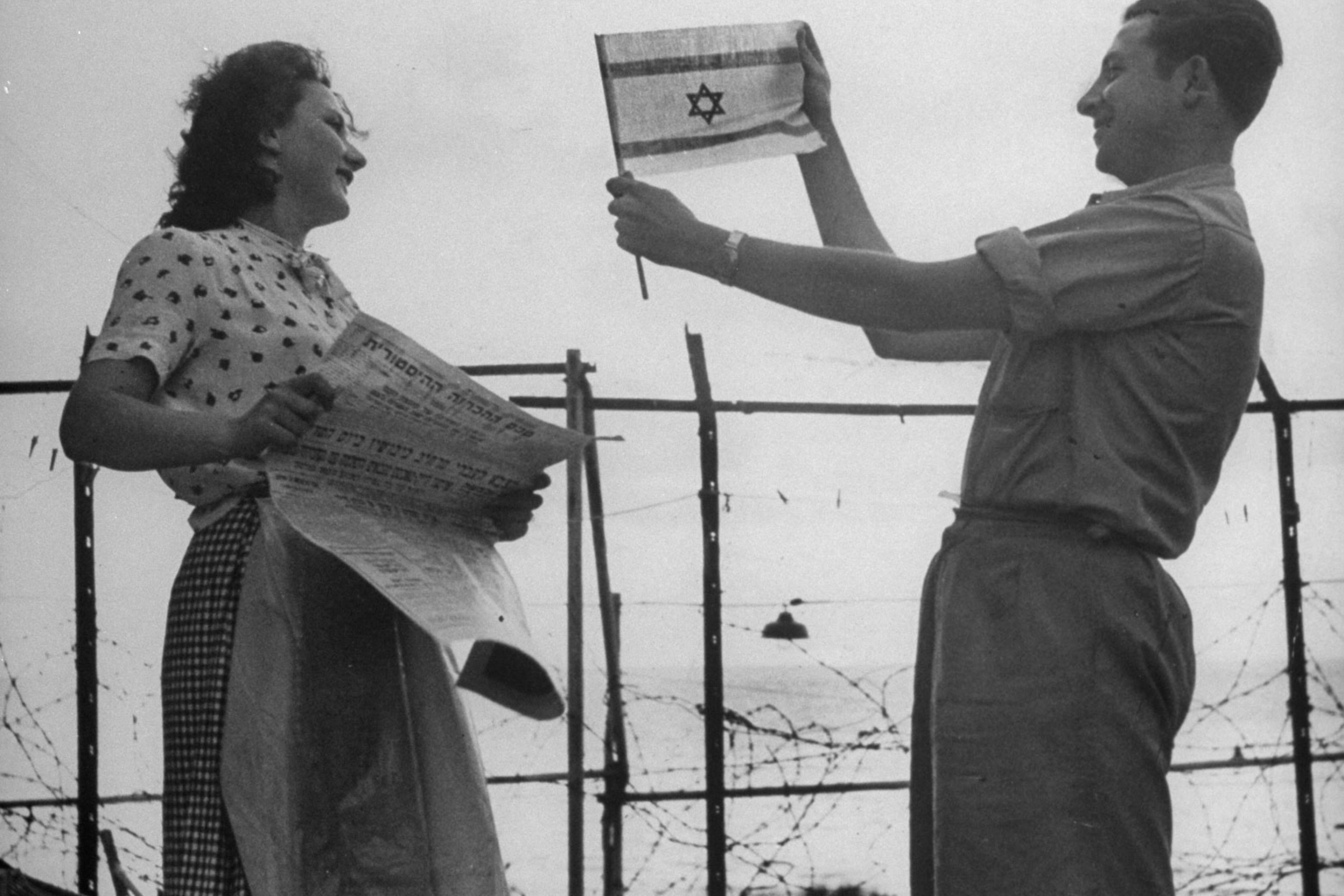Happily displaying the Israeli flag shortly after the establishment of the state of Israel, exact location unknown, May 1948.
