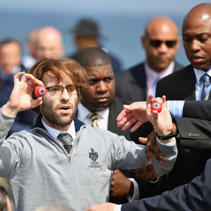 Comedian Lee Nelson is taken away by security while holding golf balls stamped with swastika as he protests against Presumptive Republican nominee for US president Donald Trump a he gave a press conference on the 9th tee at his Trump Turnberry Resort on
