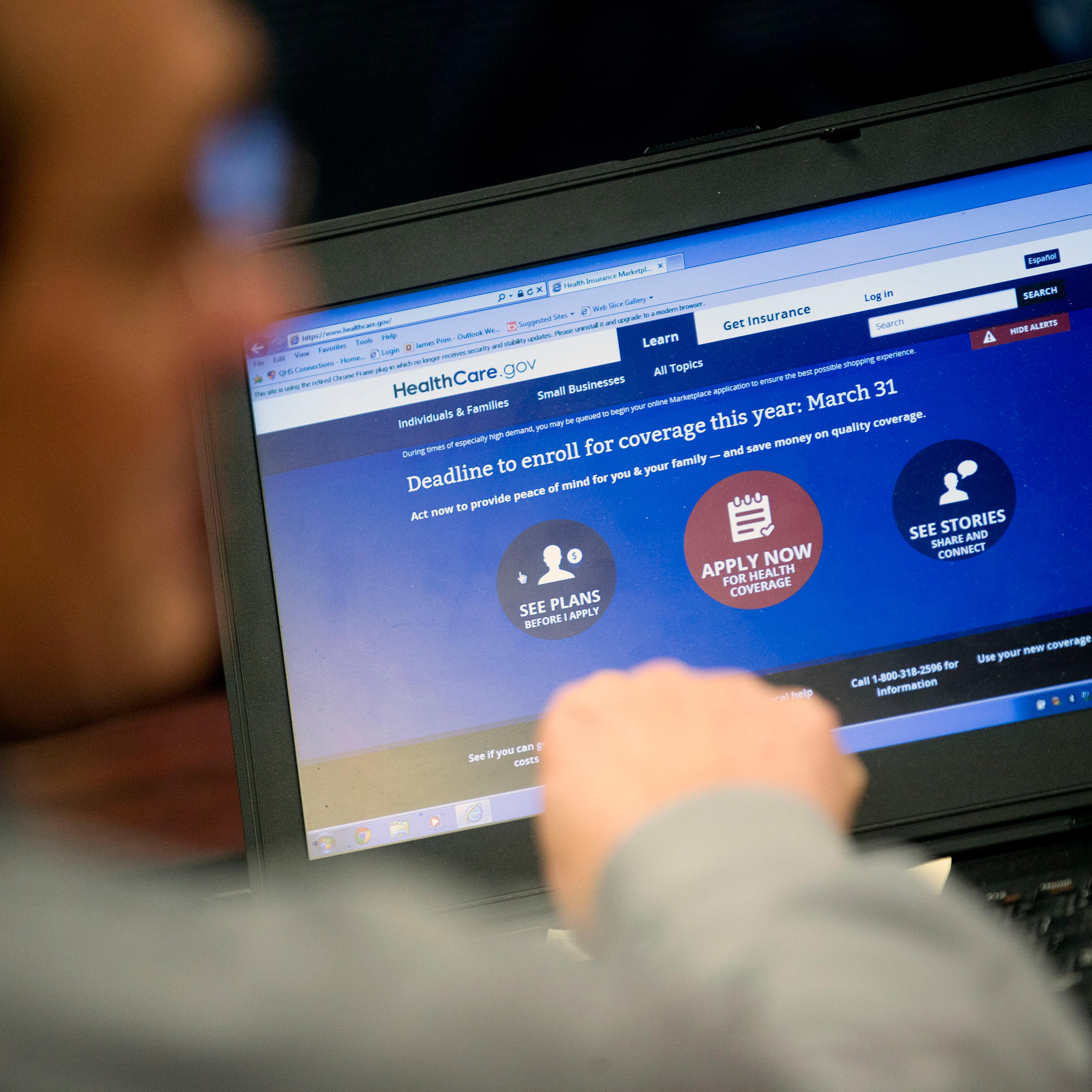 Marketplace guide Jim Prim works on the Healthcare.gov federal enrollment website as he helps a resident sign up for a health insurance plan under the Affordable Care Act at an enrollment event in Milford, Delaware on March 27, 2014.