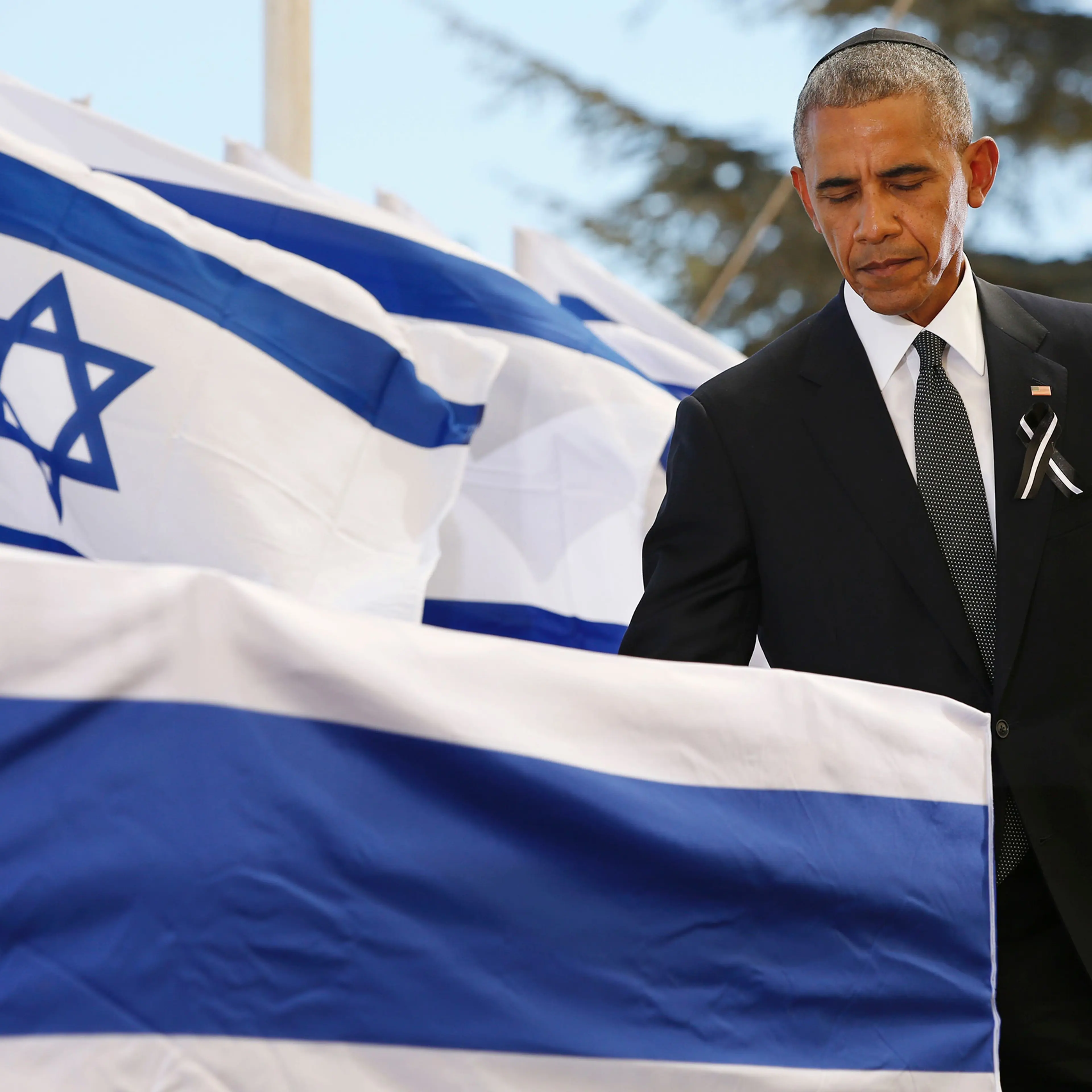 Barack Obama touches the coffin of former Israeli president and prime minister Shimon Peres after speaking during his funeral at Jerusalem's Mount Herzl national cemetery on Sept. 30, 2016.