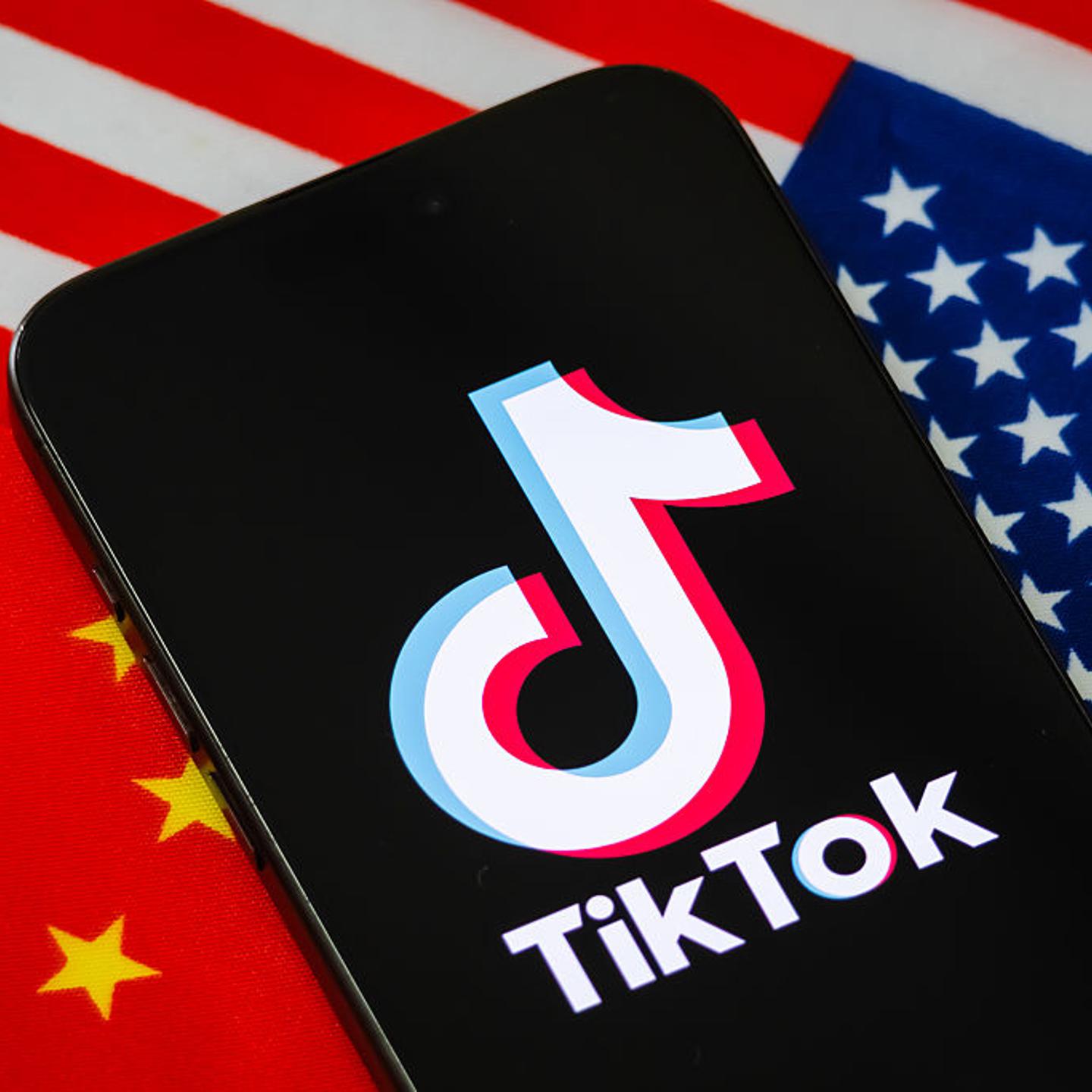 TikTok Logo Displayed On Smartphone Against Chinese And U.S. Flags