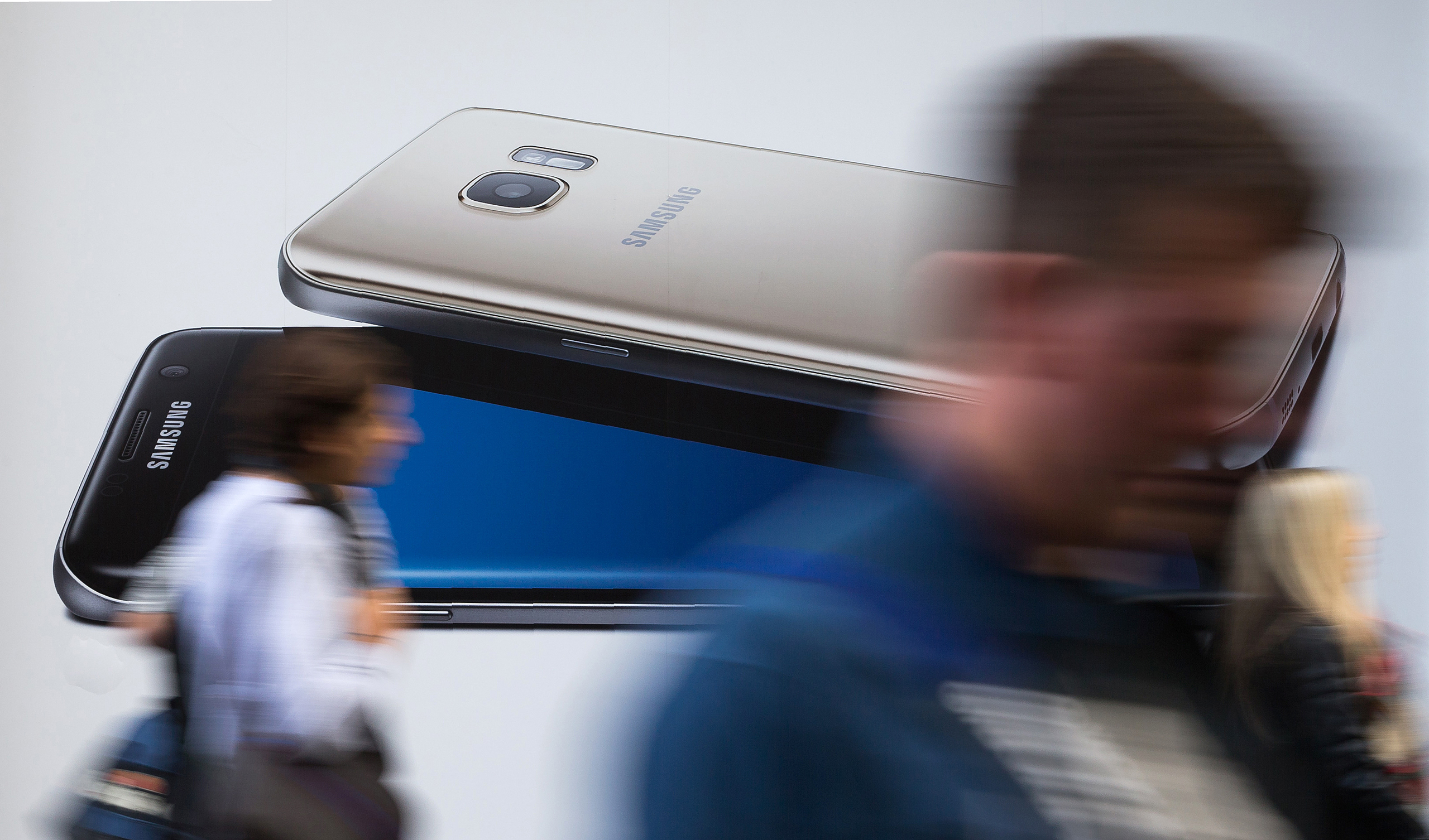 Pedestrians walk past a billboard advertising a Samsung Galaxy S7 Edge smartphone in London on October 11, 2016. Samsung suspended all production of its Galaxy Note 7 smartphone, halted sales worldwide and told customers to stop using the device, followi