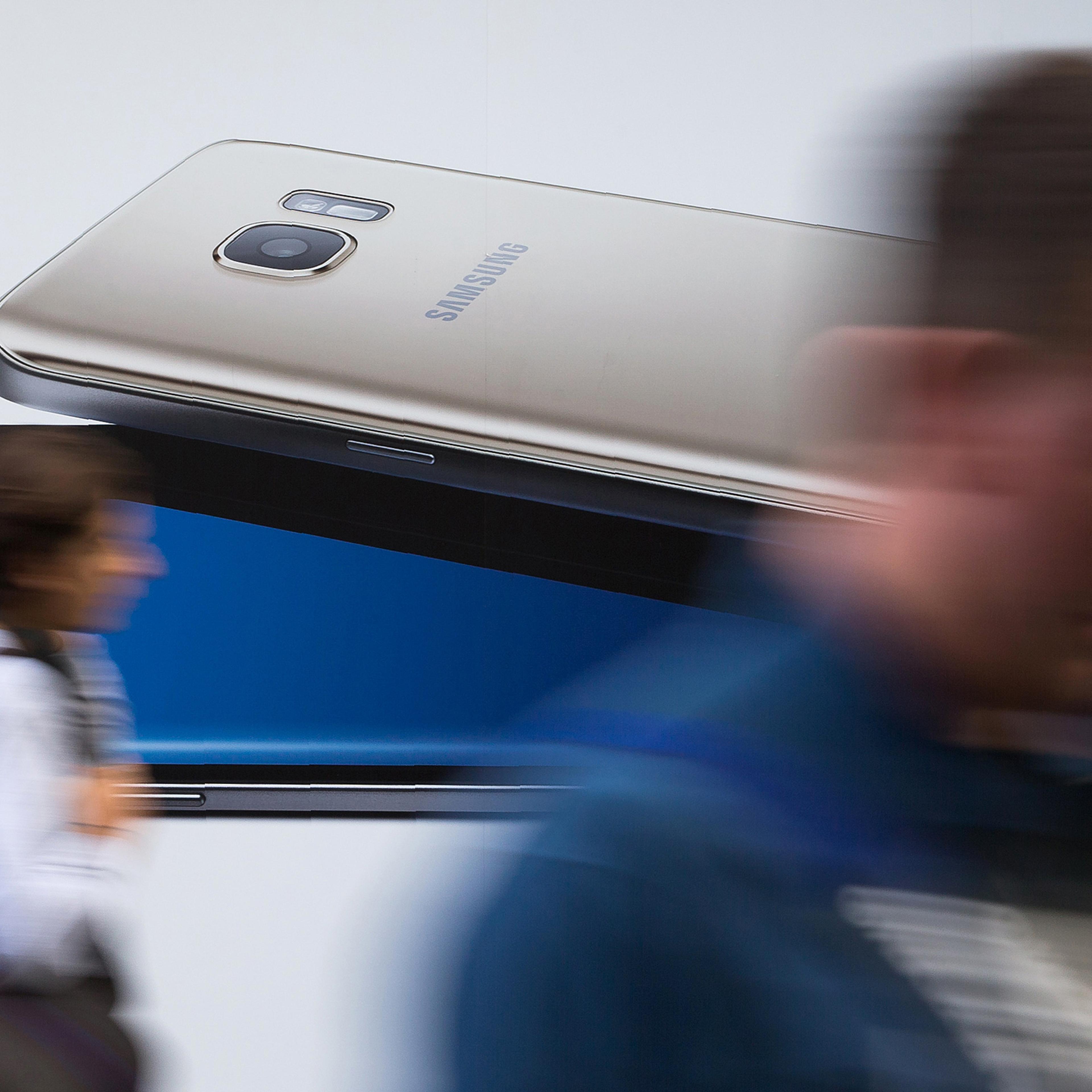 Pedestrians walk past a billboard advertising a Samsung Galaxy S7 Edge smartphone in London on October 11, 2016. Samsung suspended all production of its Galaxy Note 7 smartphone, halted sales worldwide and told customers to stop using the device, followi