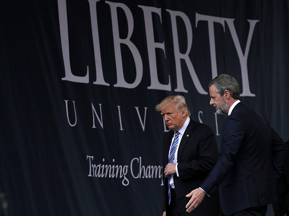 Accompanied by President Jerry Falwell (R), U.S. President Donald Trump (L) leaves after he delivered keynote address during the commencement at Liberty University May 13, 2017 in Lynchburg, Virginia.