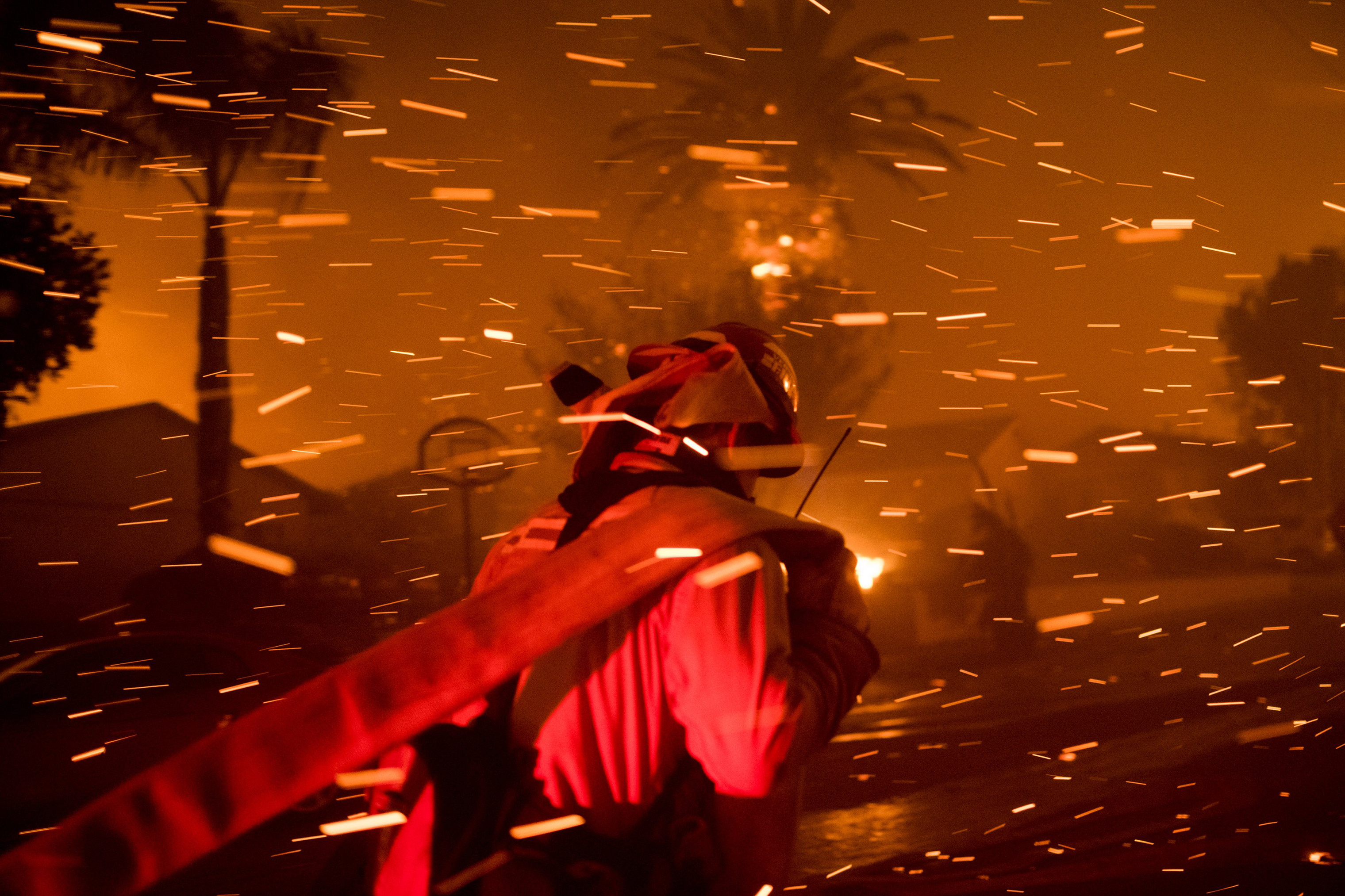 A fireman runs to set up a hoseline to try and extinguish the flame of the Woolsey Fire in Thousand Oaks, Calif. on Nov. 8.