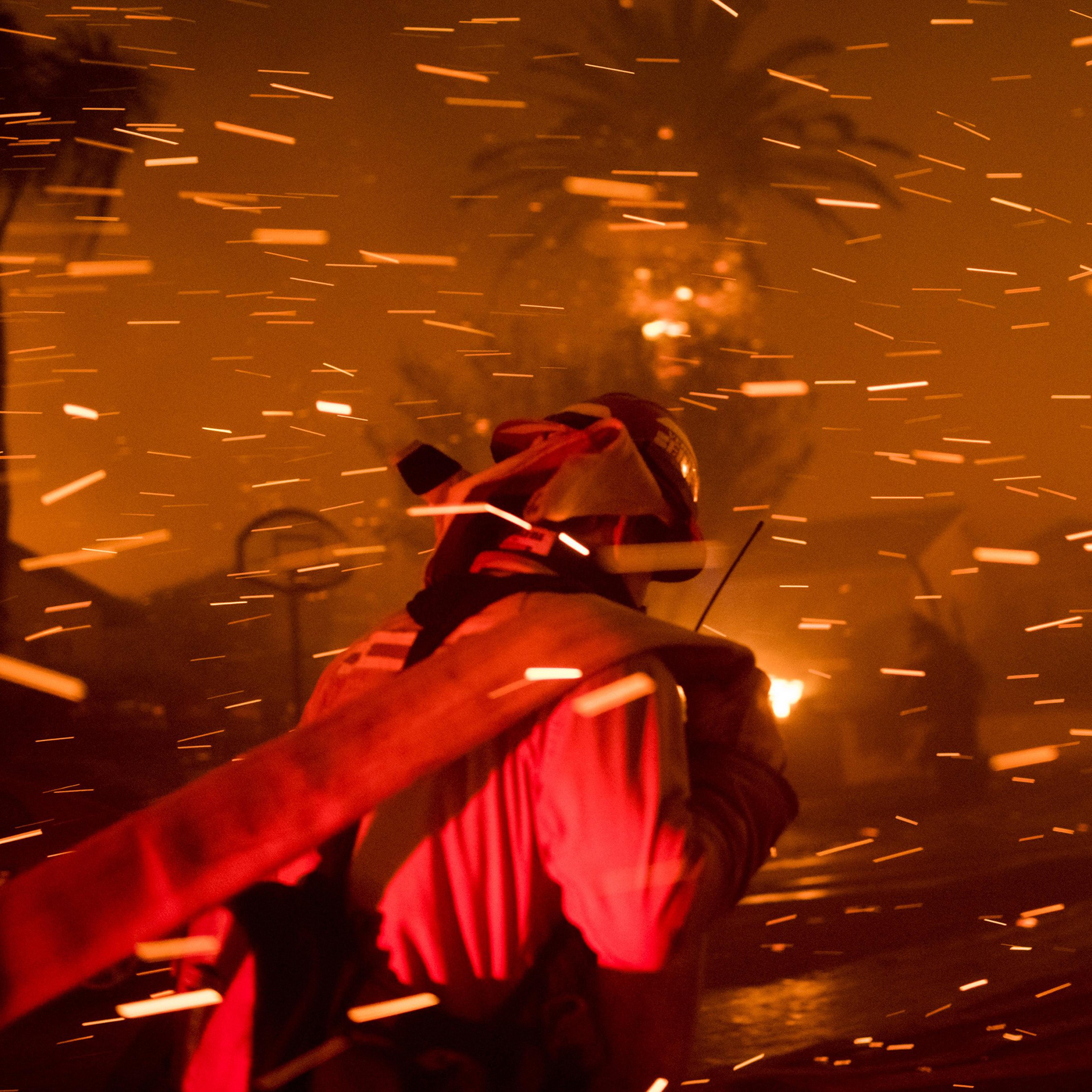 A fireman runs to set up a hoseline to try and extinguish the flame of the Woolsey Fire in Thousand Oaks, Calif. on Nov. 8.