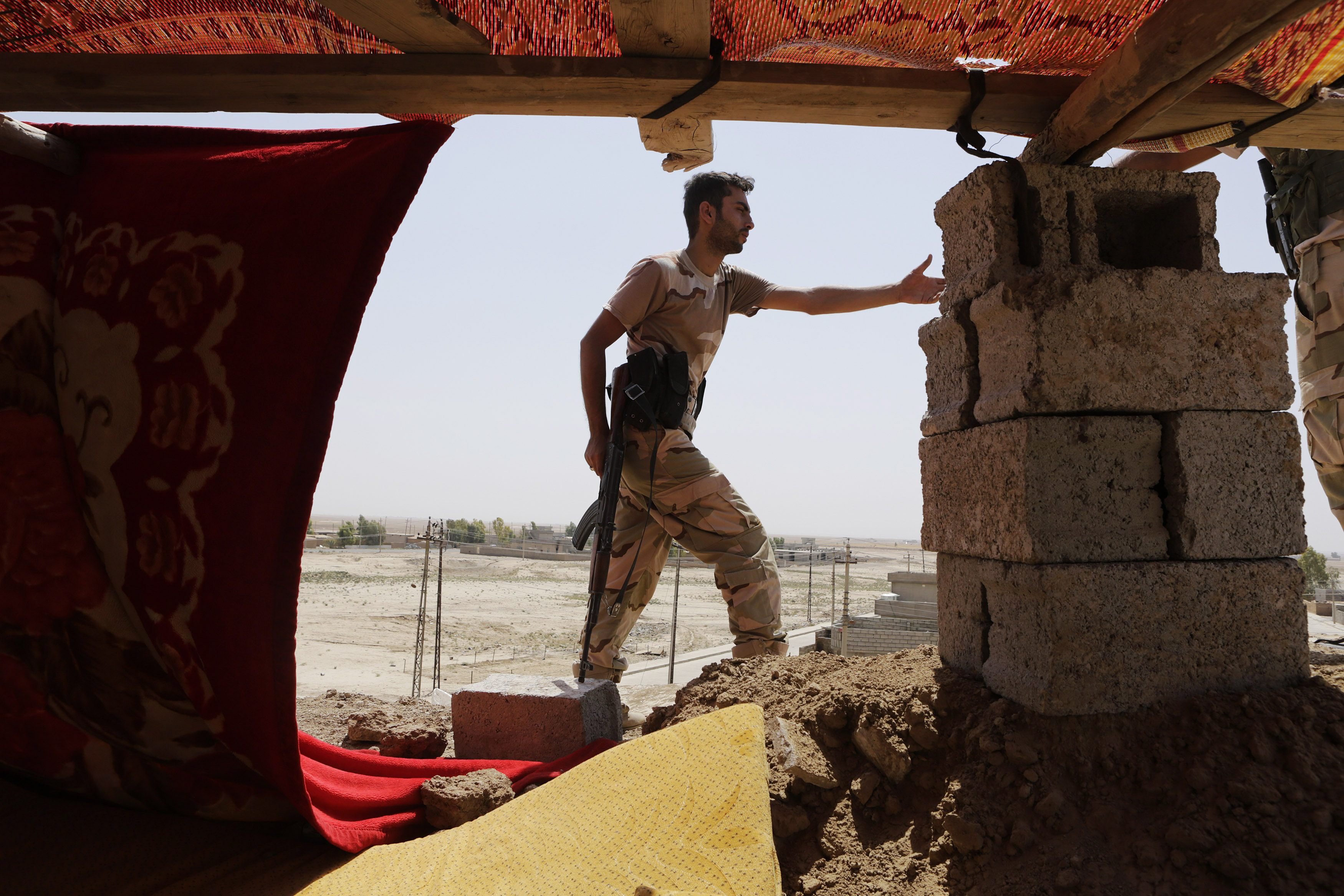 A Kurdish Peshmerga fighter stands guard at the Bakirta frontline near the town of Makhmur, south of Erbil, the capital of Iraqi Kurdistan on Aug. 27, 2014.