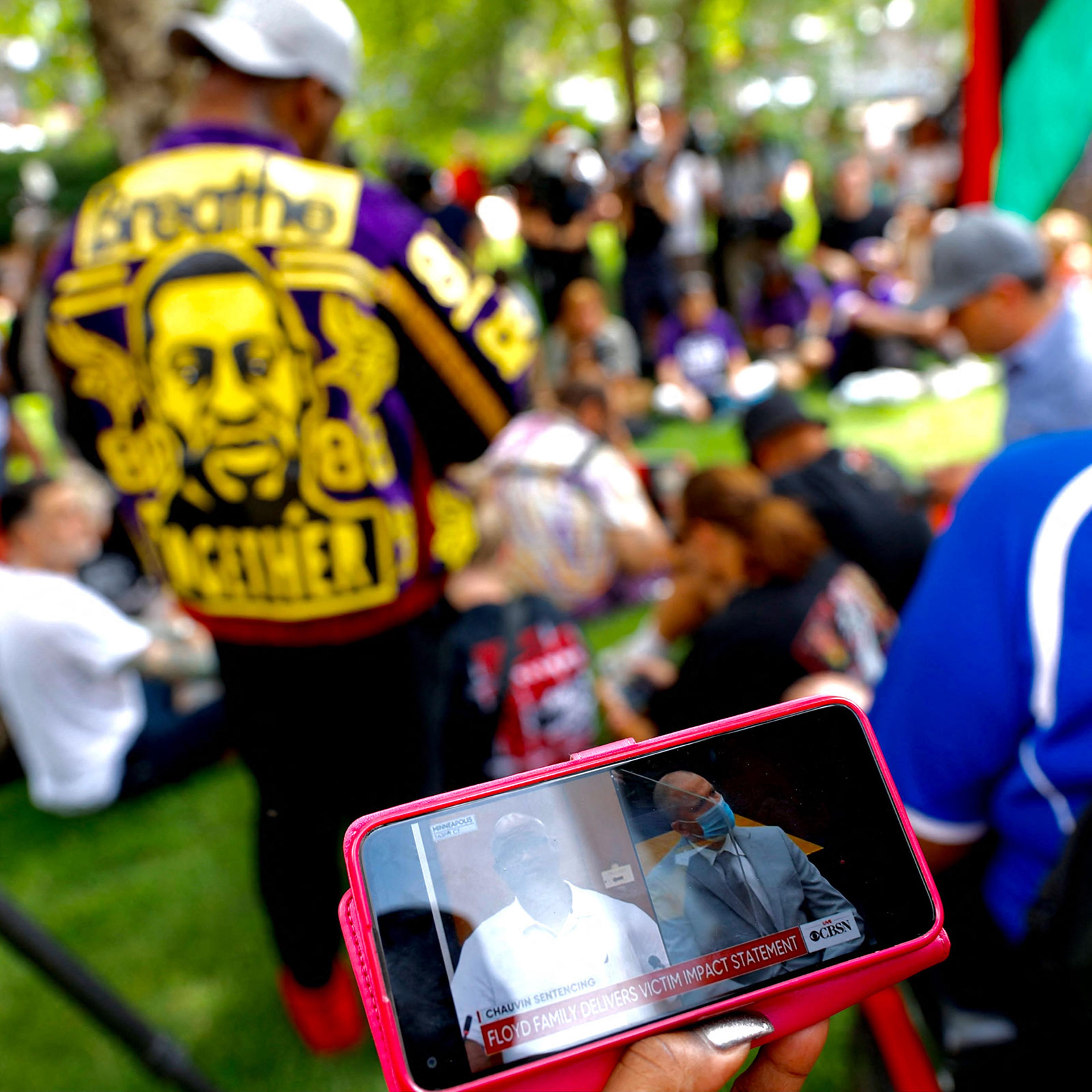 People watch the sentencing hearing of former Minneapolis Police officer Derek Chauvin outside the Hennepin County Government Center in Minneapolis on June 25, 2021.