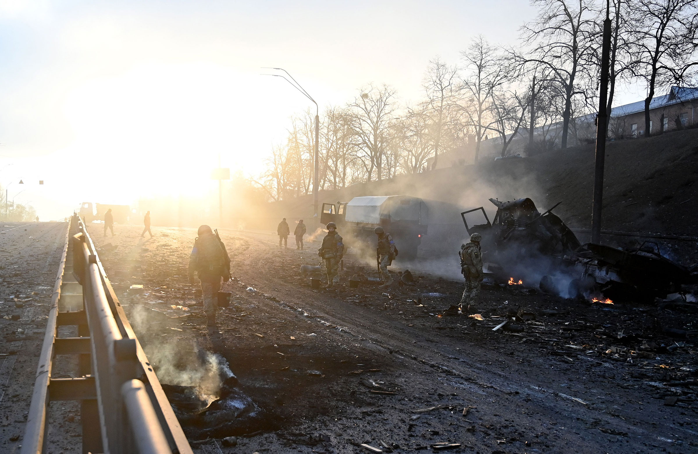 Ukrainian service members look for and collect unexploded shells after a fight with a Russian raiding group, according to Ukrainian service personnel at the scene, in the Ukrainian capital of Kyiv in the morning of Feb. 26, 2022.