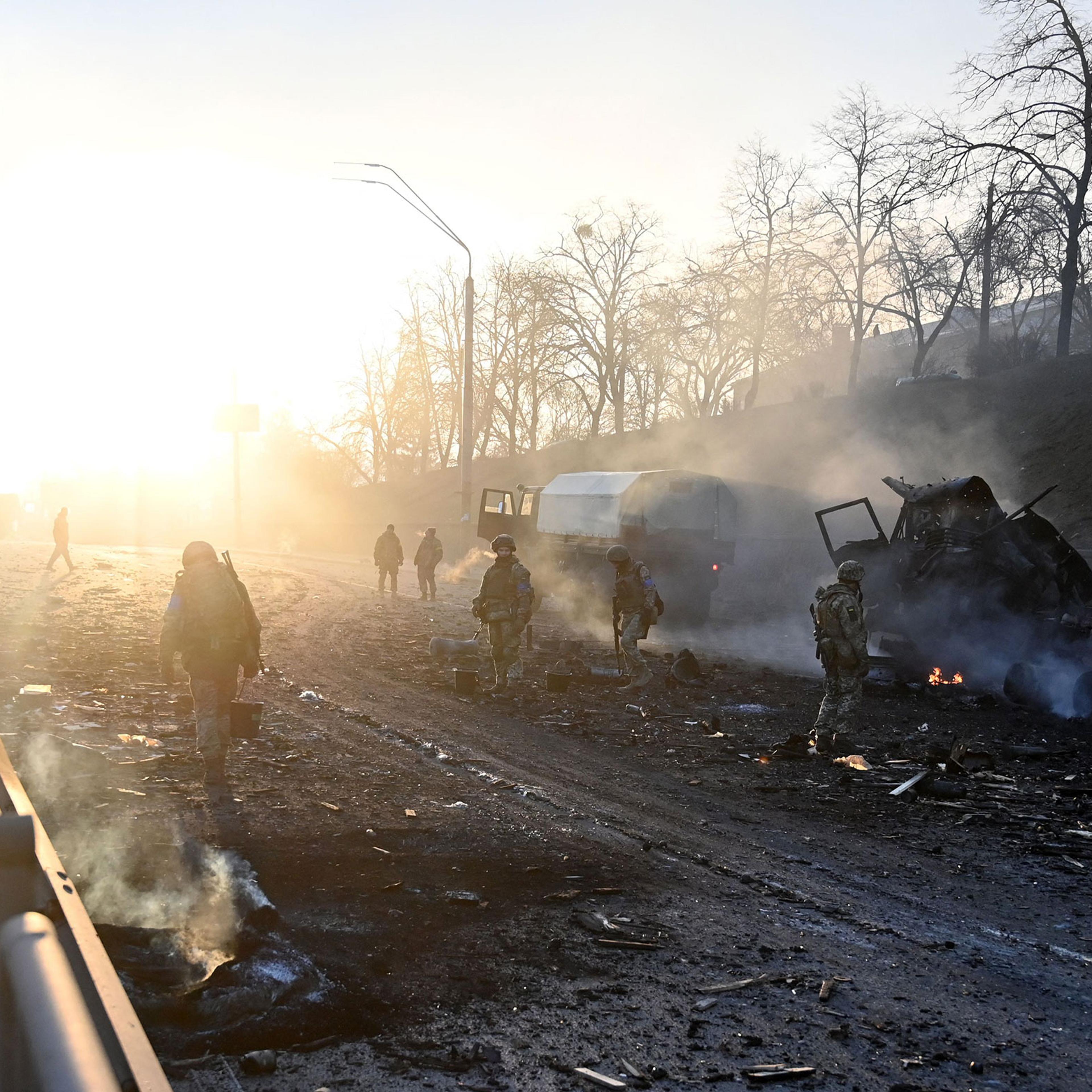 Ukrainian service members look for and collect unexploded shells after a fight with a Russian raiding group, according to Ukrainian service personnel at the scene, in the Ukrainian capital of Kyiv in the morning of Feb. 26, 2022.
