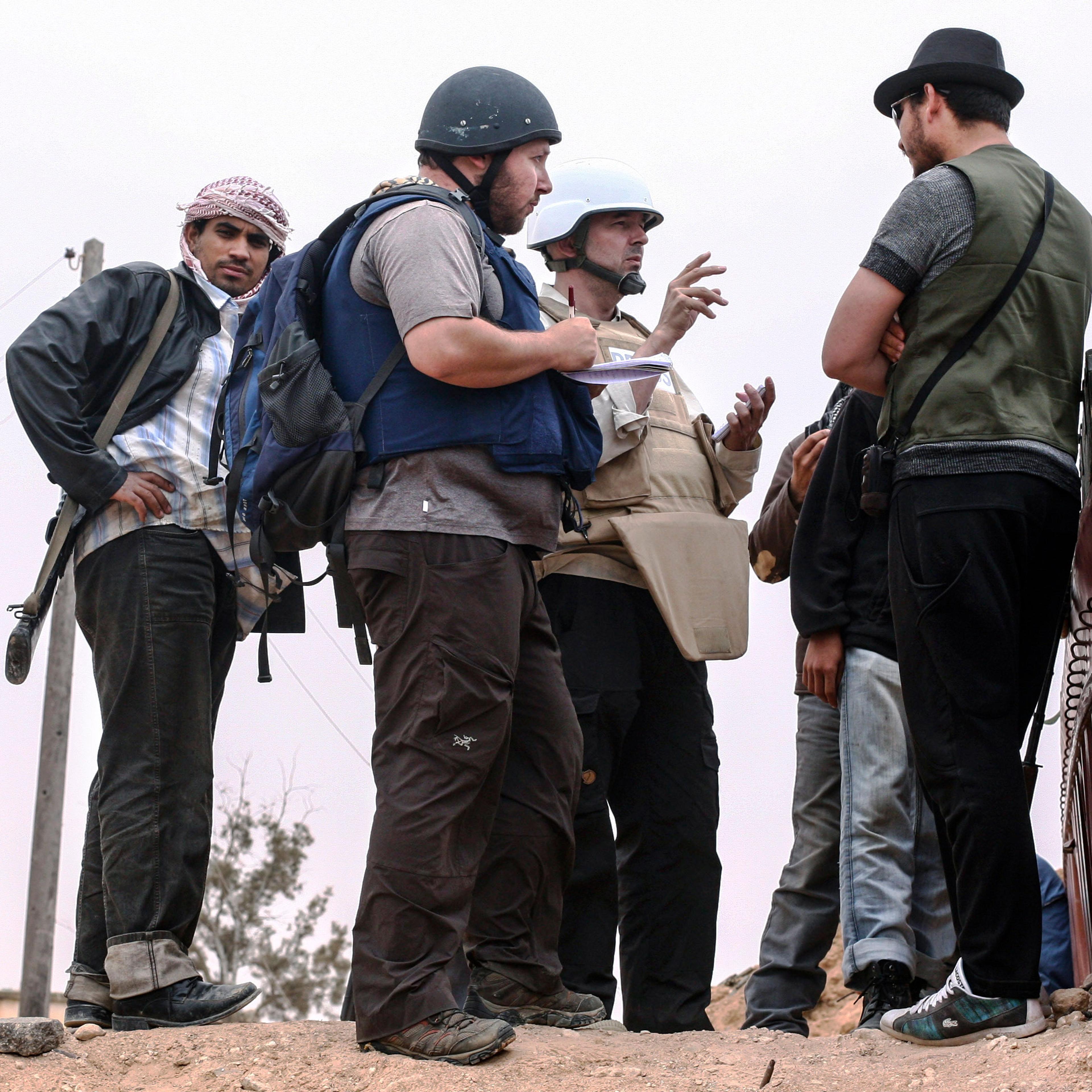 American journalist Steven Sotloff (center with black helmet) talks to Libyan rebels on the Al Dafniya front line