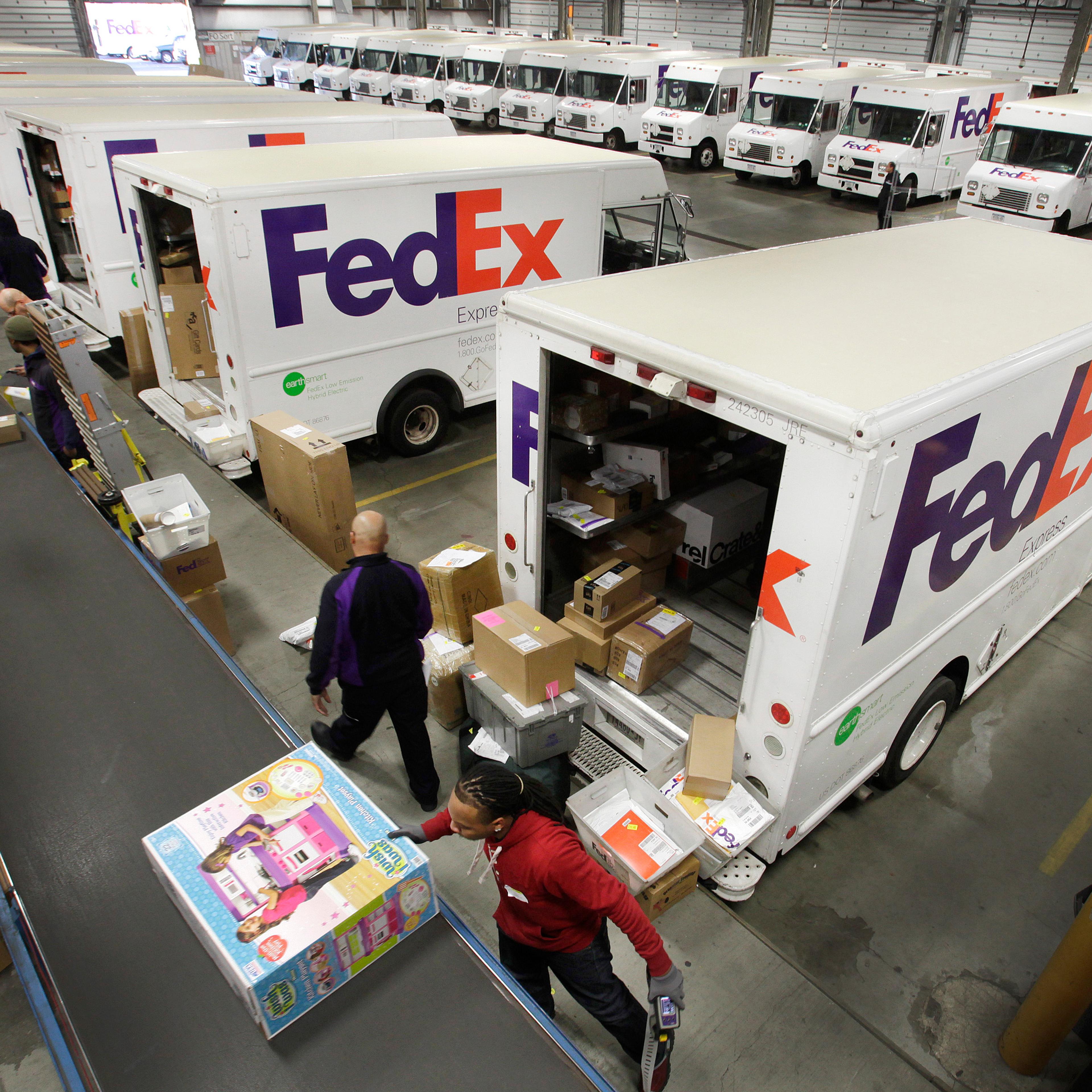 FedEx employees fill their trucks for deliveries at a FedEx sorting facility in the Bronx, New York on Dec. 15, 2014.