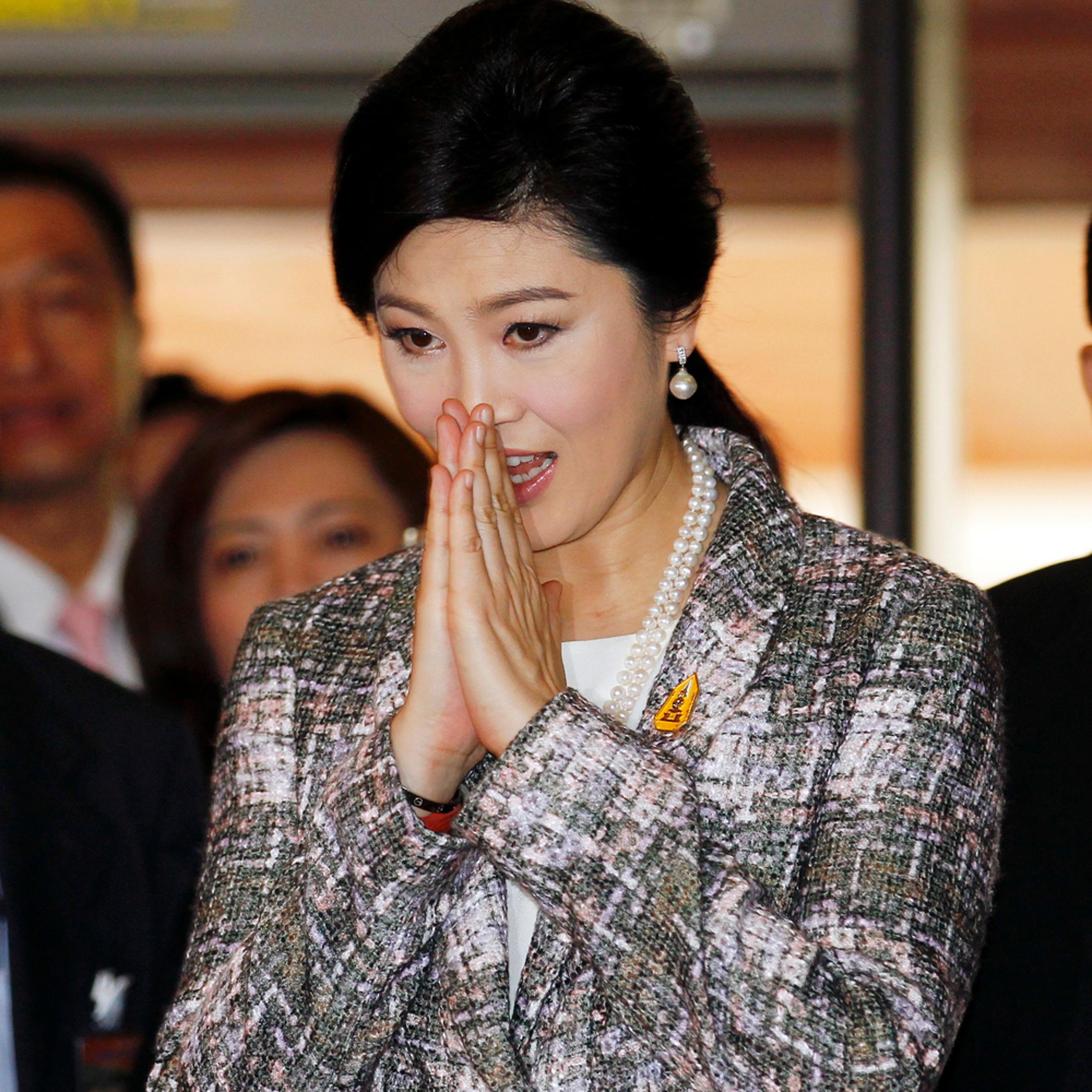 Ousted former Prime Minister Yingluck Shinawatra greets in a traditional way as she arrives at Parliament before the National Legislative Assembly meeting in Bangkok