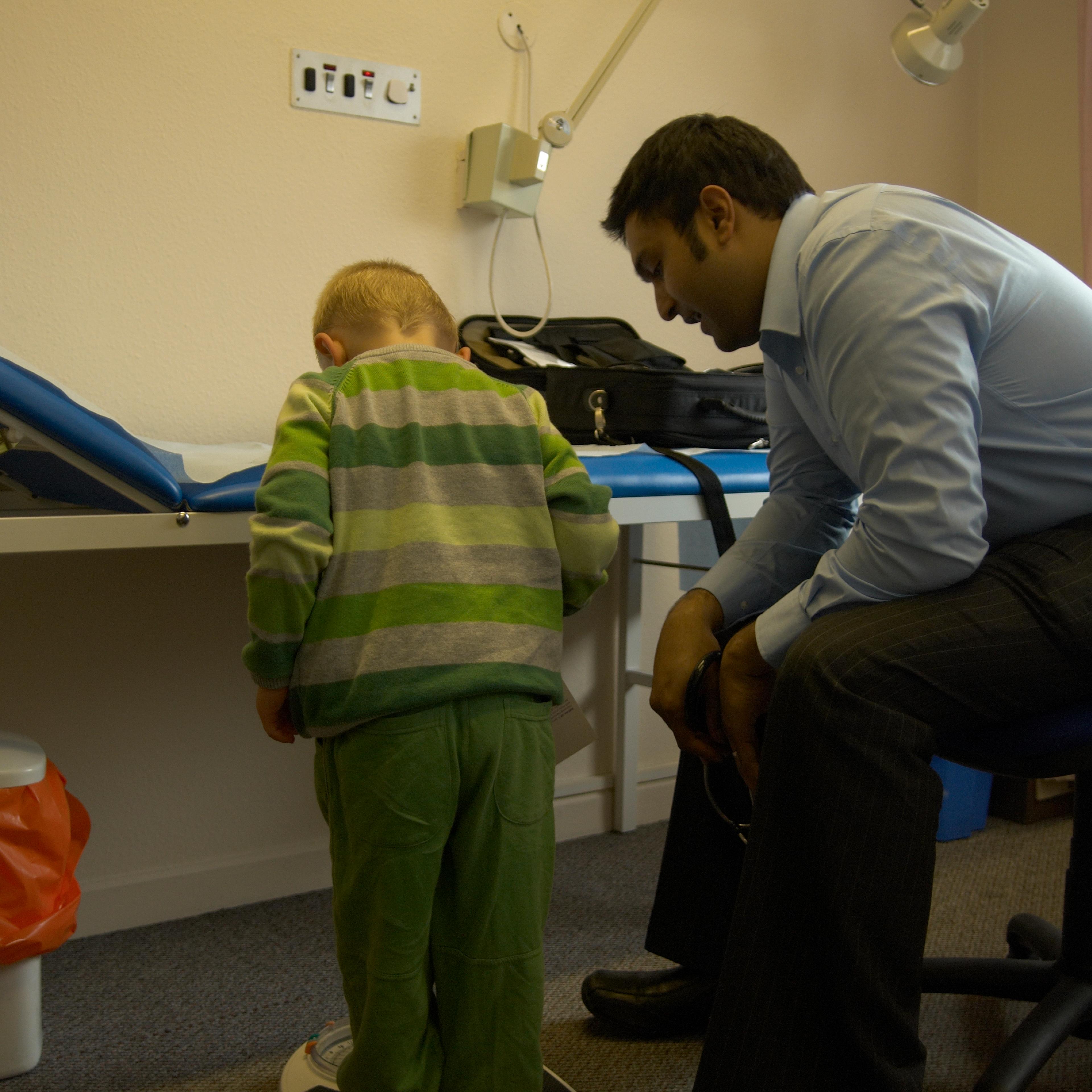 Doctor with child (2-4 years old) on weighing scales