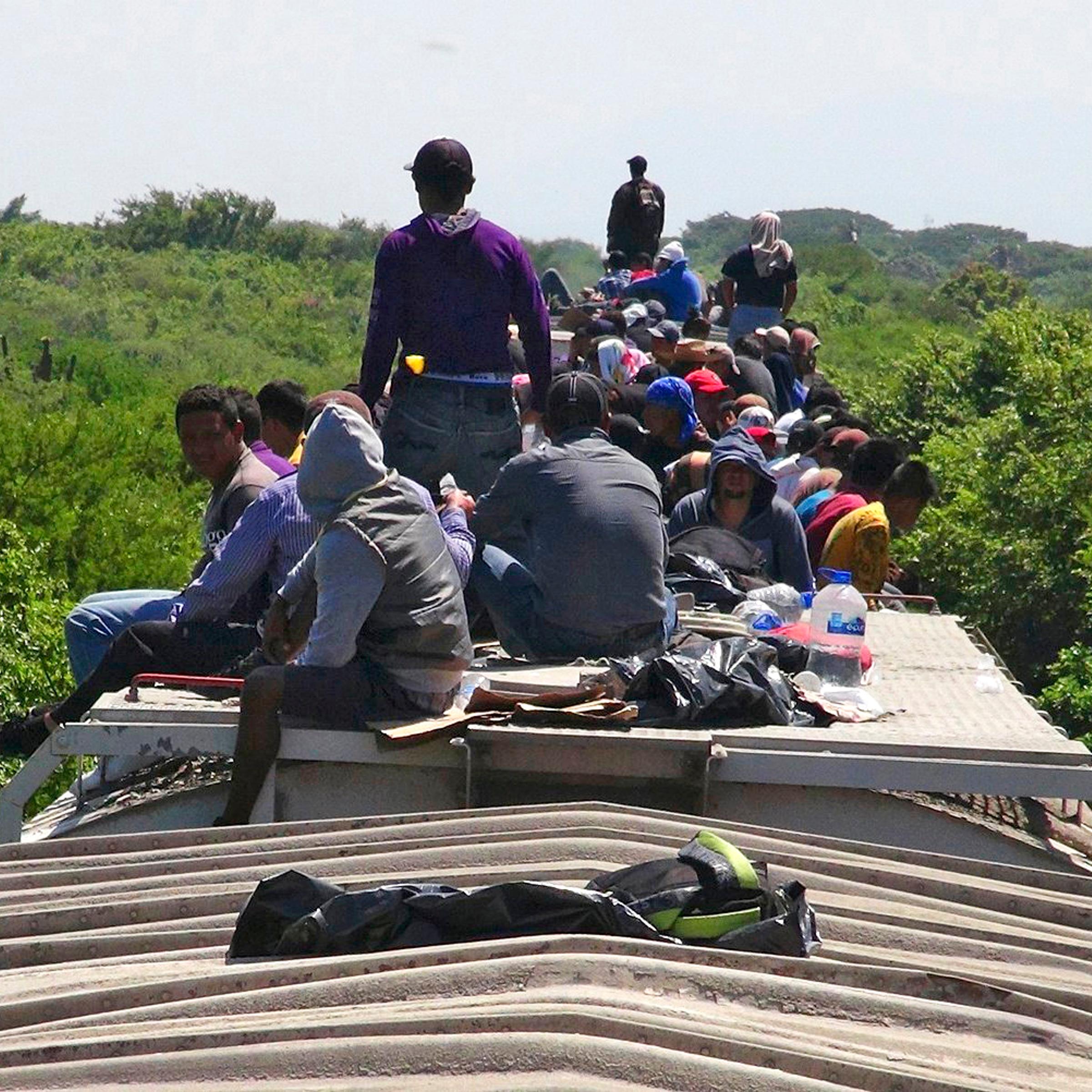 Unaccompanied minors ride atop the wagon of a freight train, known as La Bestia (The Beast) in Ixtepec, in the Mexican state of Oaxaca on June 18, 2014.