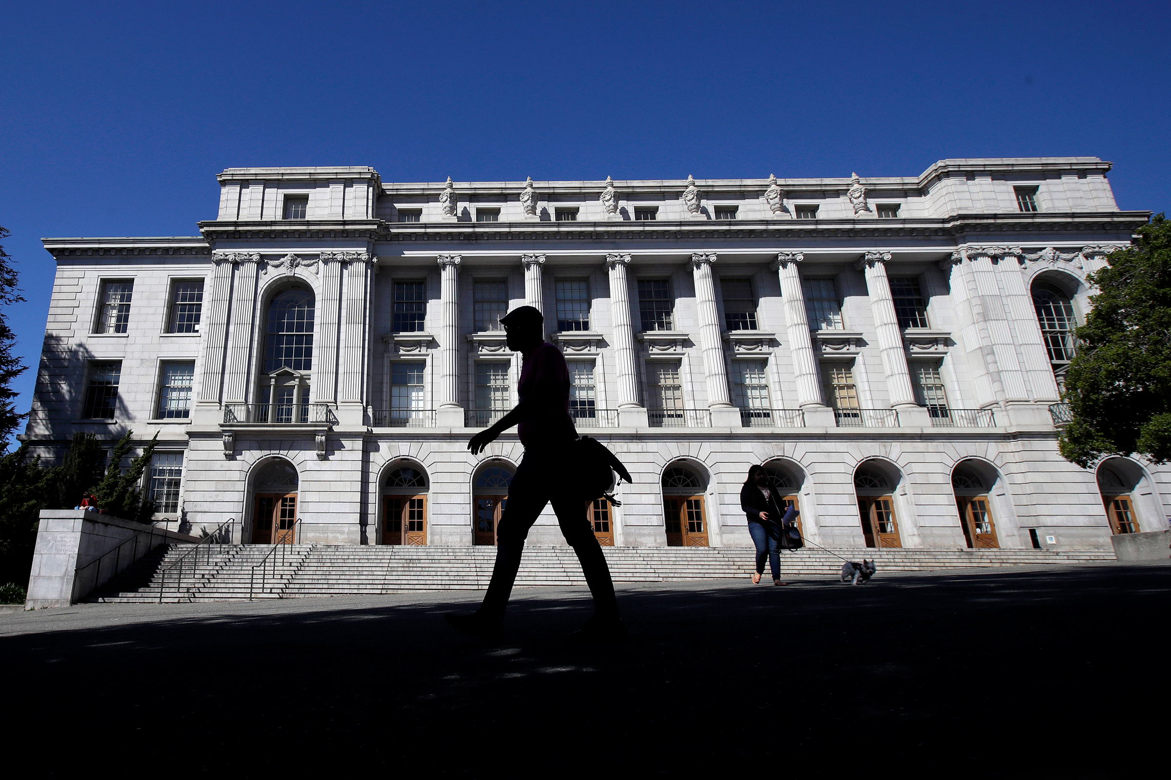 People walk in front of Wheeler Hall on the University of California campus