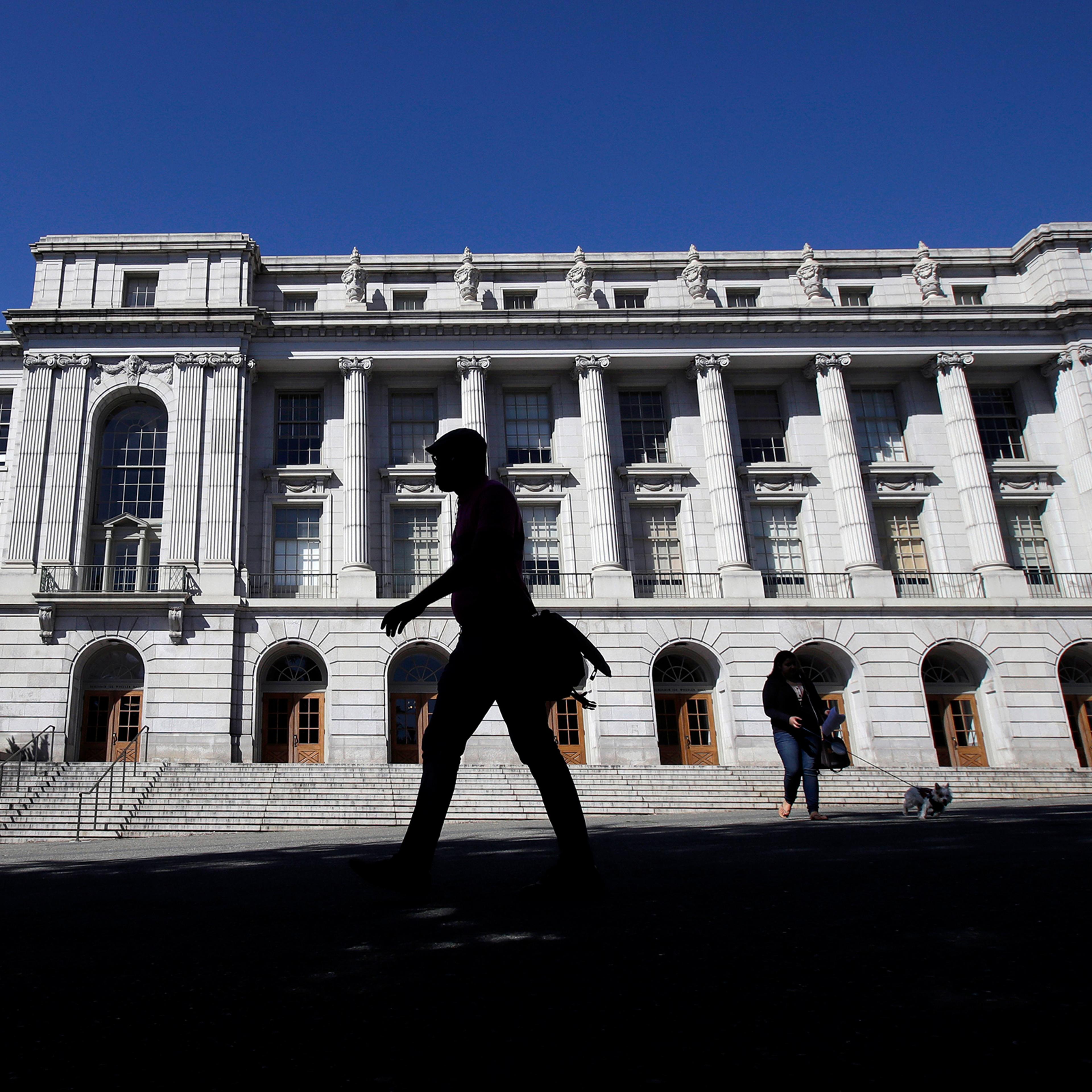 People walk in front of Wheeler Hall on the University of California campus
