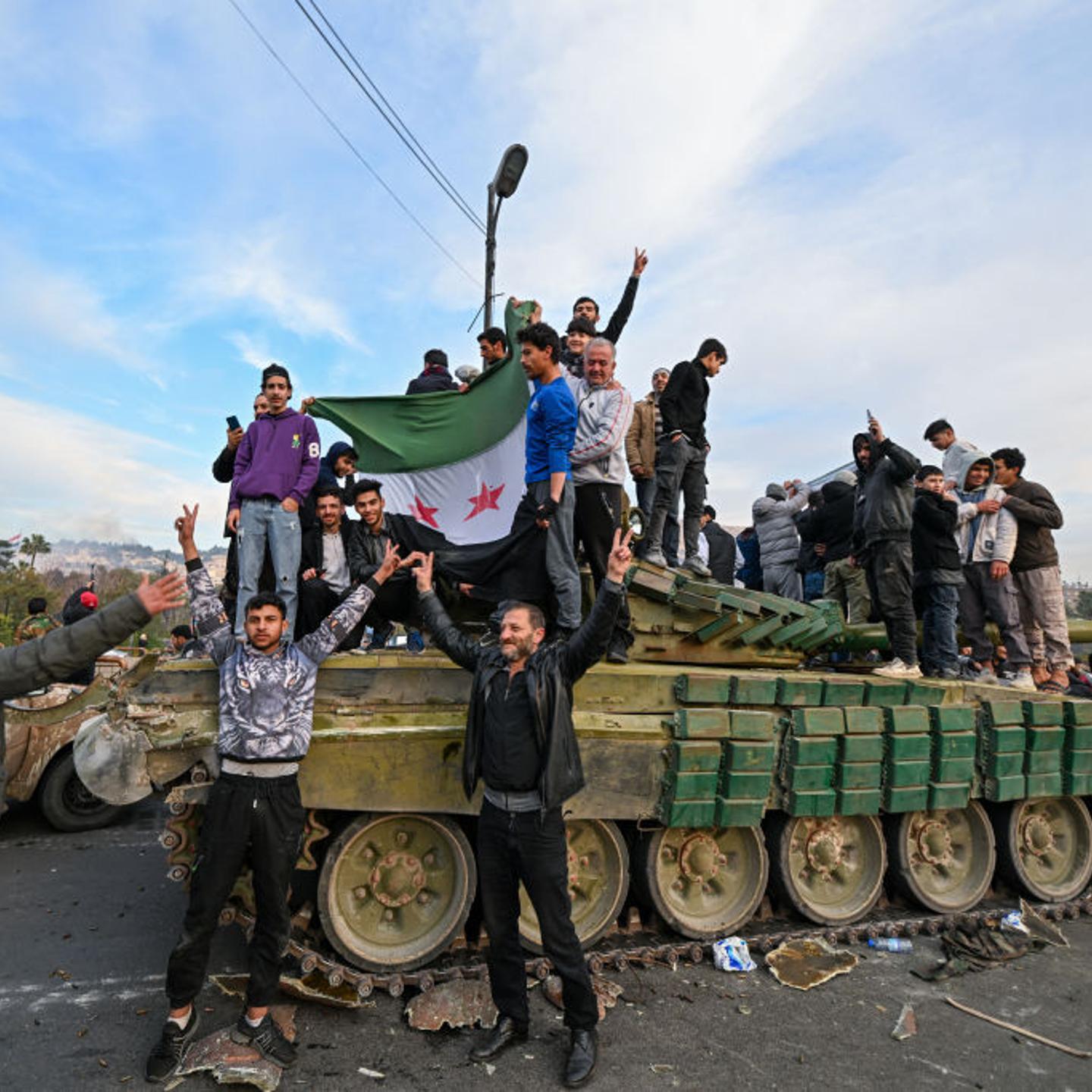 People celebrate with anti-government fighters at Umayyad Square in Damascus on Dec. 8, 2024.