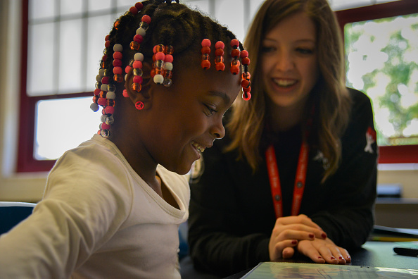 Americorps reading tutor Kelly Meany, L, gives one-on-one reading instructions to 7-year-old 2nd grader Madissen Moody at C.W. Harris Elementary School on Friday, September 19, 2014, in Washington, DC.