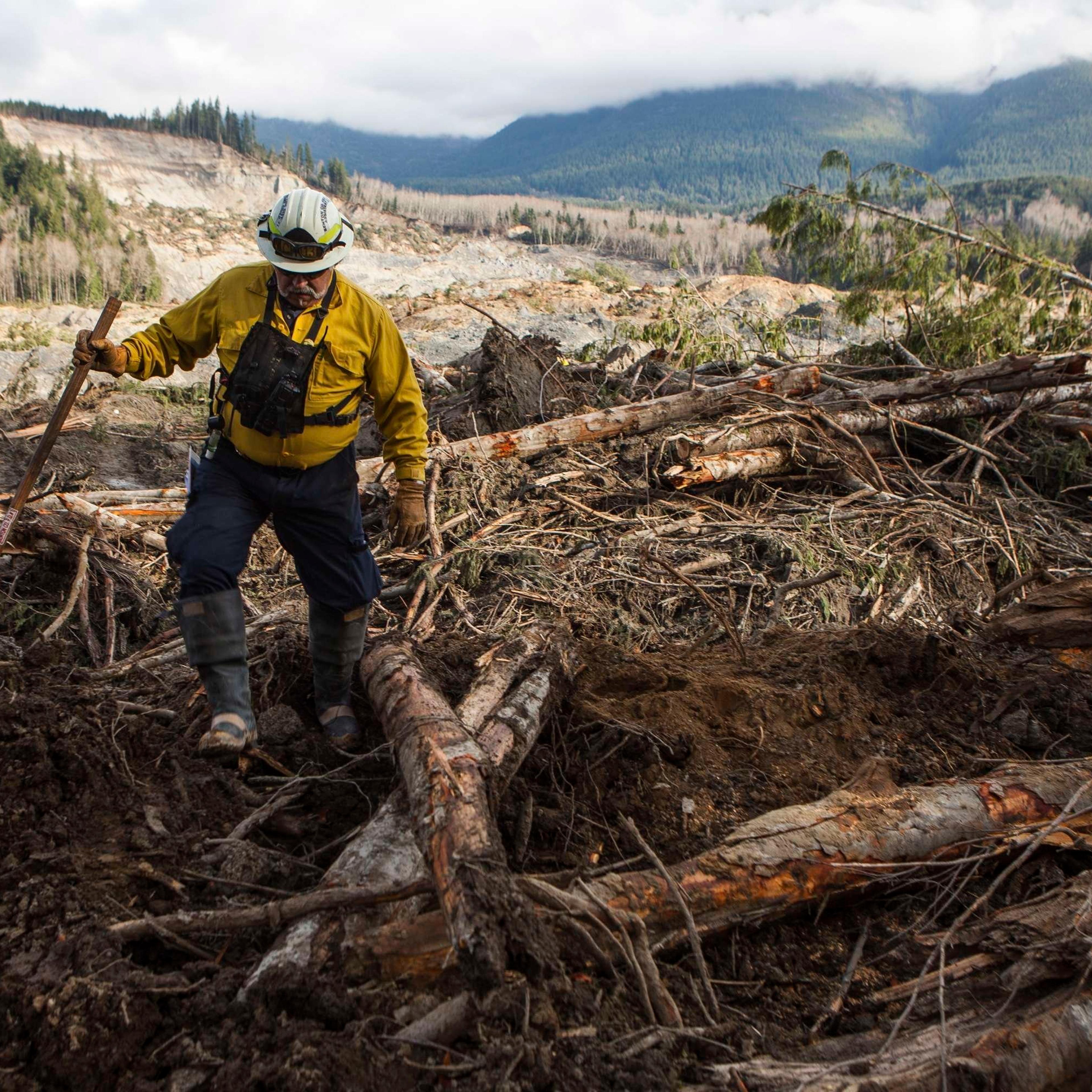 Benton County Assistant Fire Chief Jack Coats makes his way over debris left by a mudslide in Oso