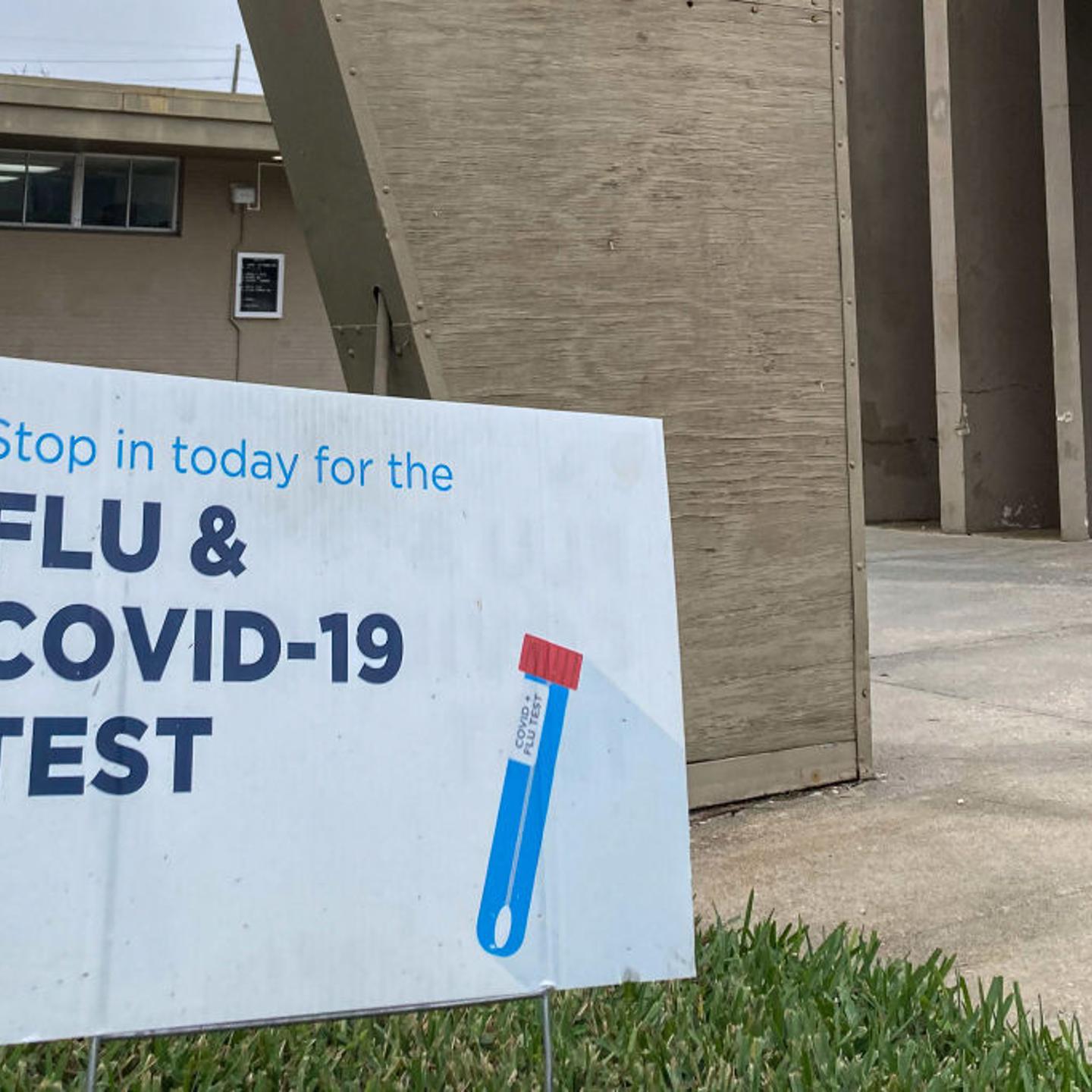A sign advertising flu and COVID-19 testing is seen in front