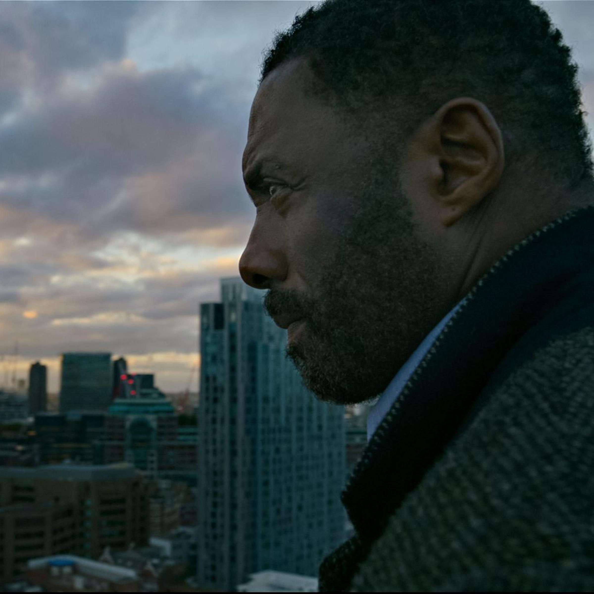 Luther wears his typical gray coat and has a furrowed brow.