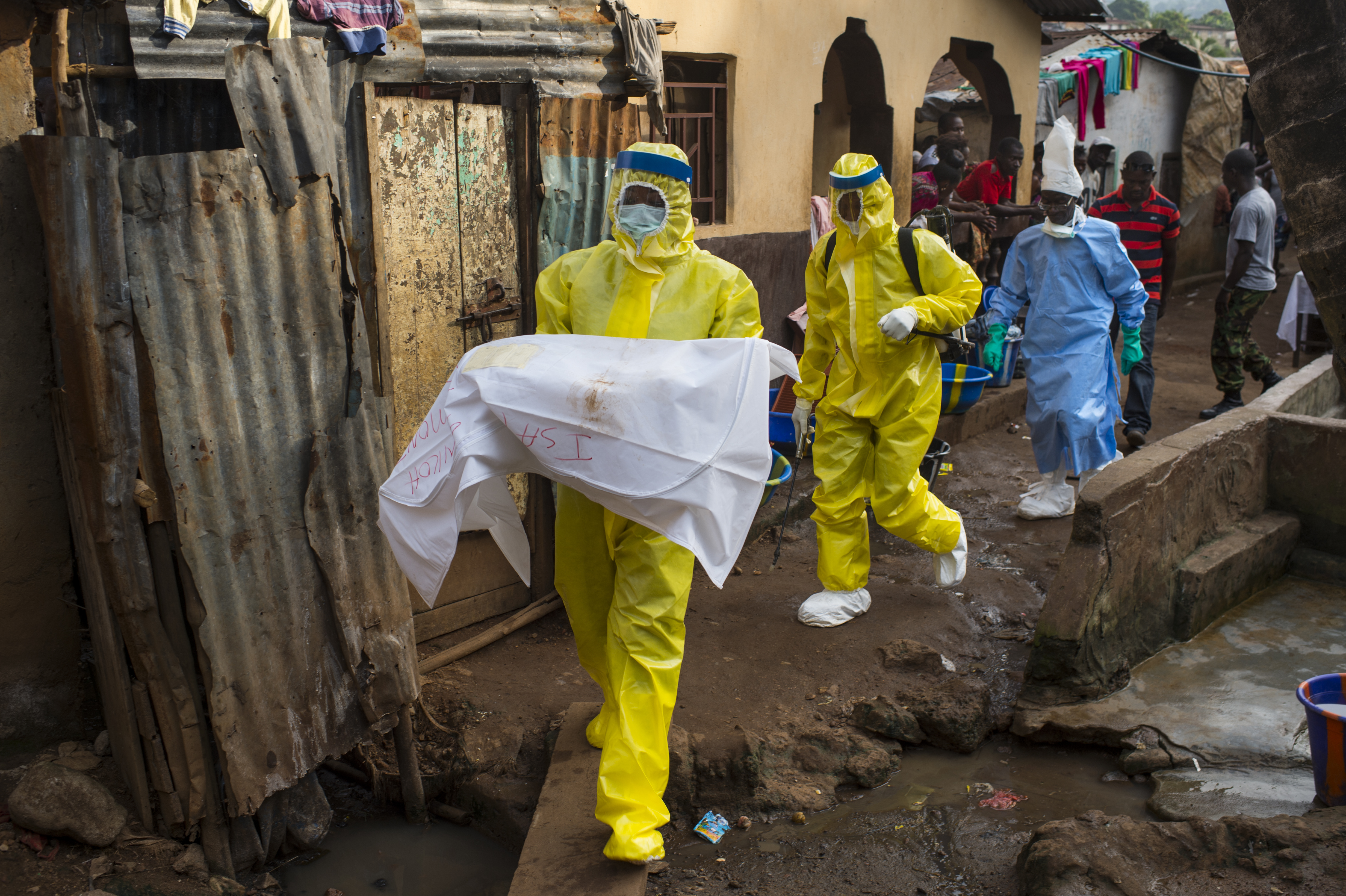 An aid worker carries a deceased 7-month old baby from Race Course area, after she died in Freetown, Sierra Leone, on Nov. 23, 2014.