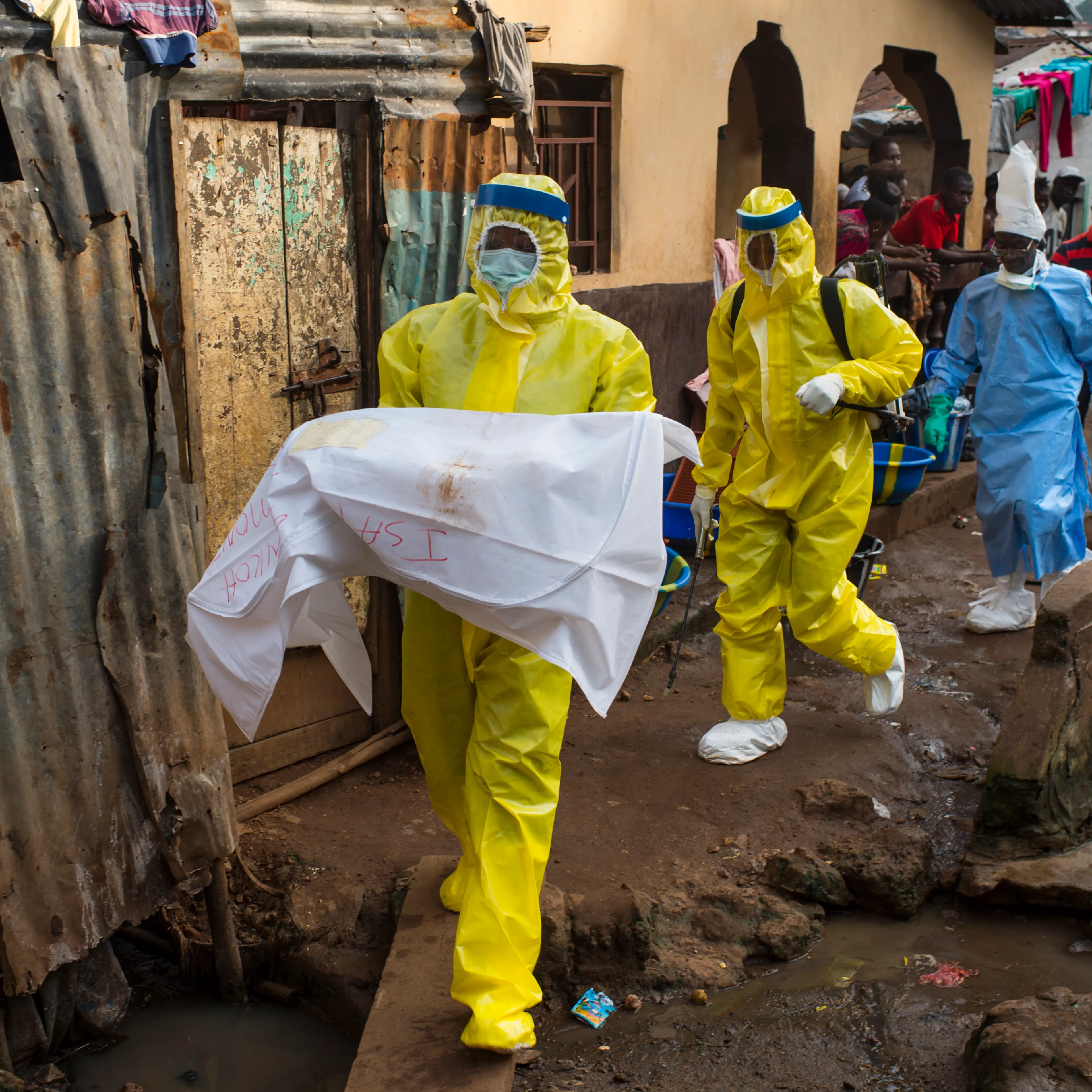 An aid worker carries a deceased 7-month old baby from Race Course area, after she died in Freetown, Sierra Leone, on Nov. 23, 2014.