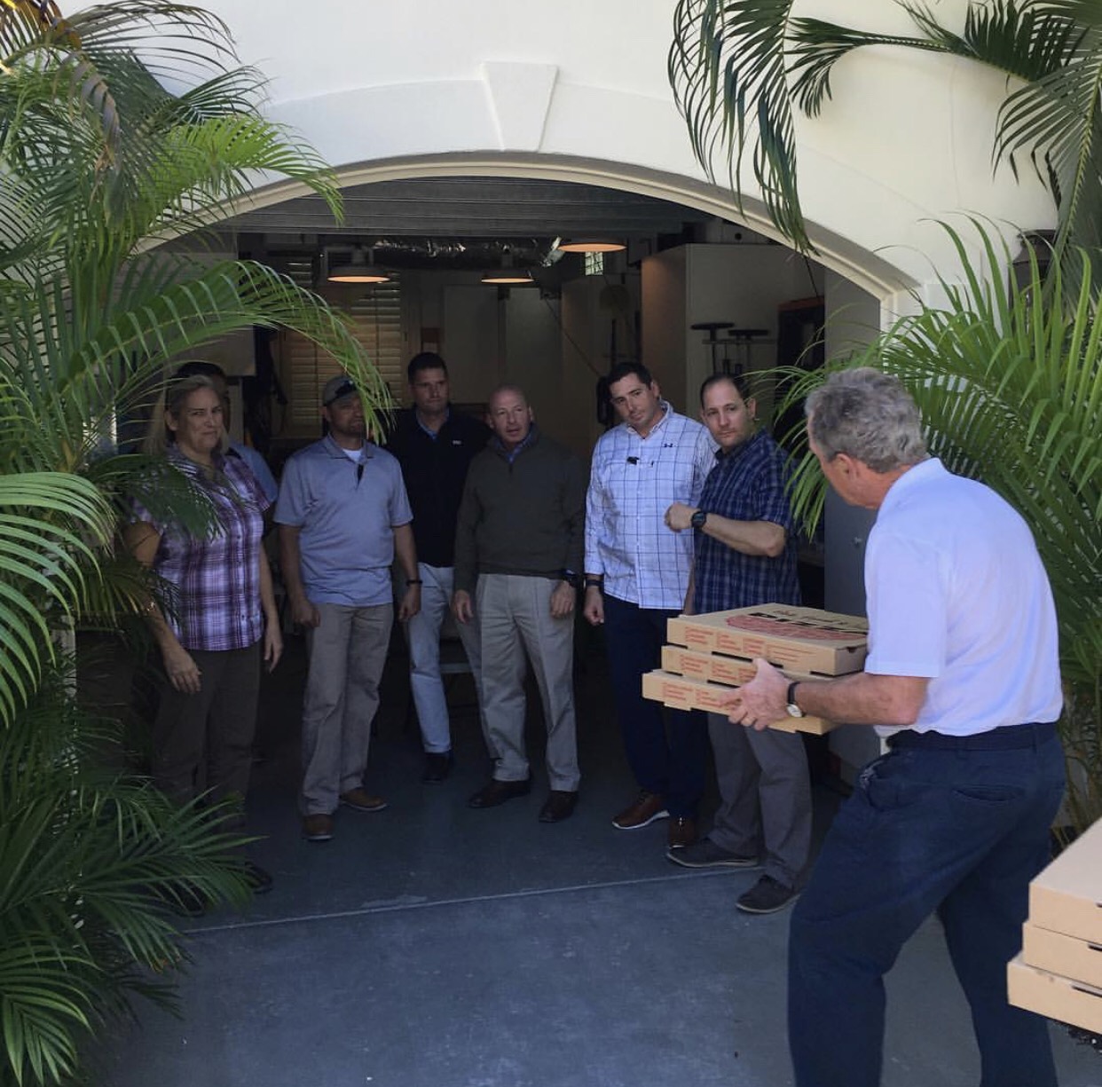 Former president George W. Bush hands pizza to his secret service personnel. 