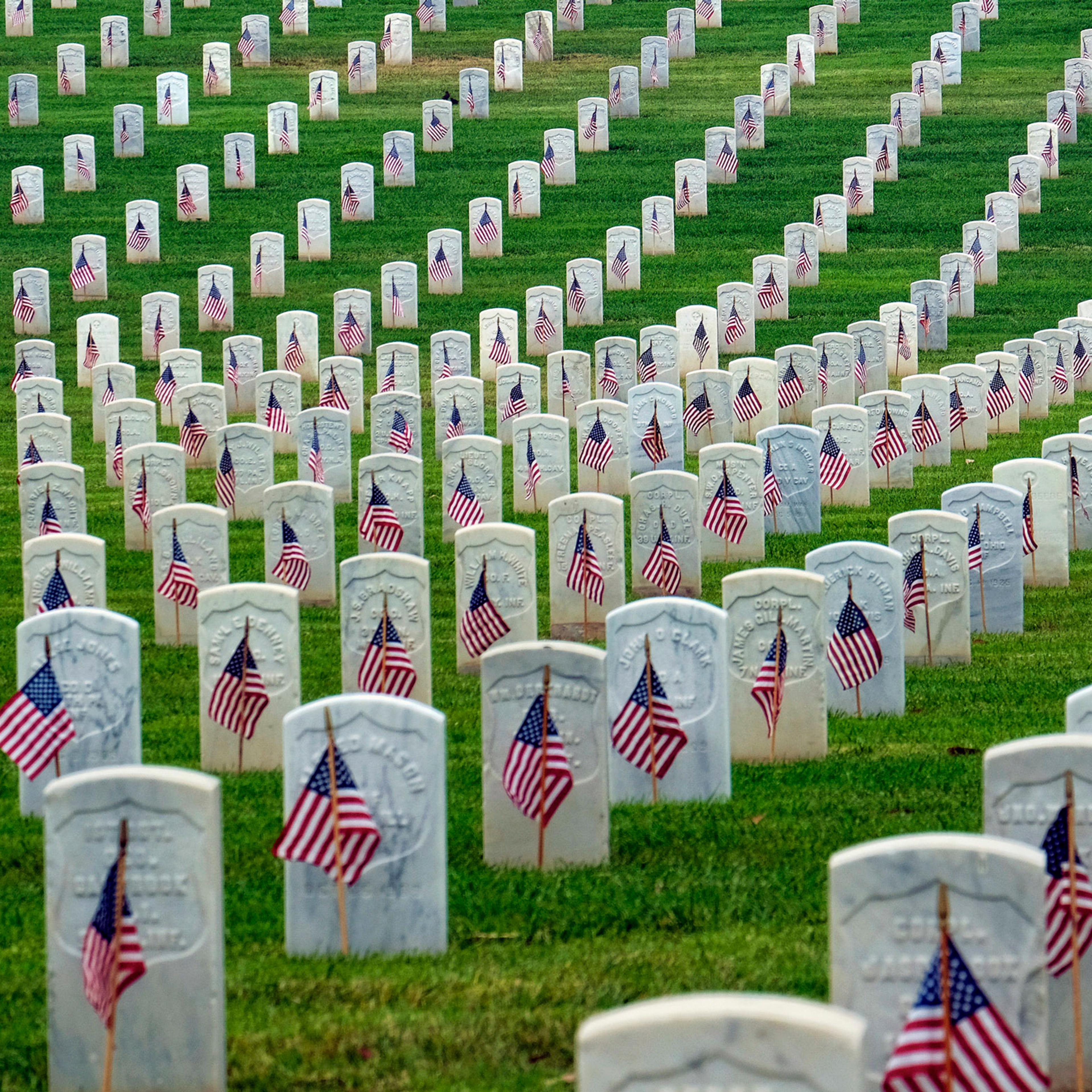 A Boy Scout salutes at the foot of a grave after volunteers placed flags at the Los Angeles National Cemetery on Saturday, May 28, 2016 in preparation for Memorial Day. (AP Photo/Richard Vogel