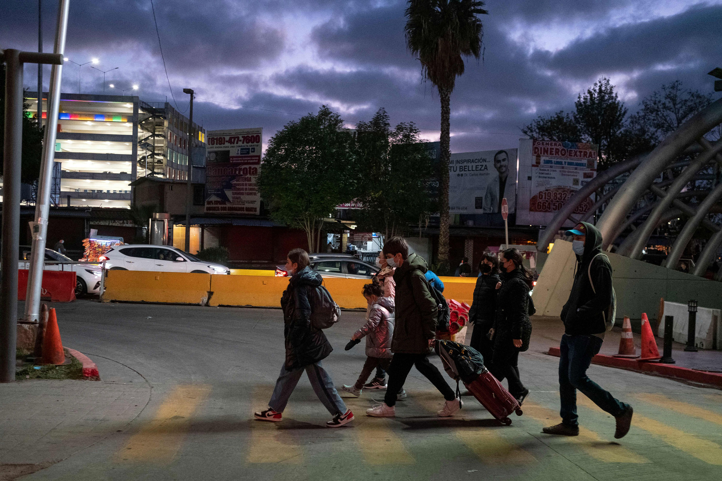 Ukrainian citizens walk along with advocates on the Mexican side of the border