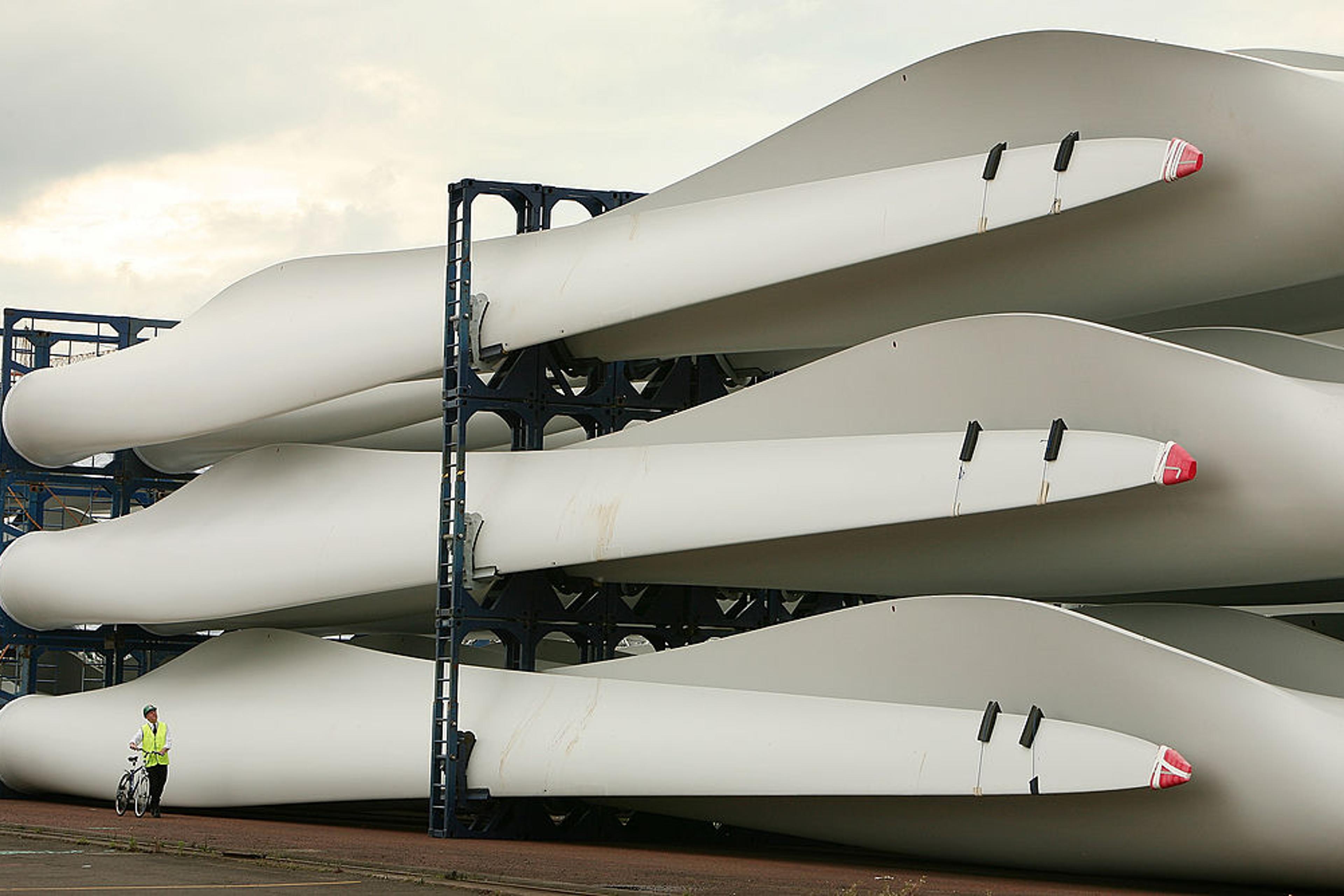 A worker passes stored wind turbine blades at the Harland & Wolff shipyard on Aug. 14, 2008 in Belfast, Northern Ireland.