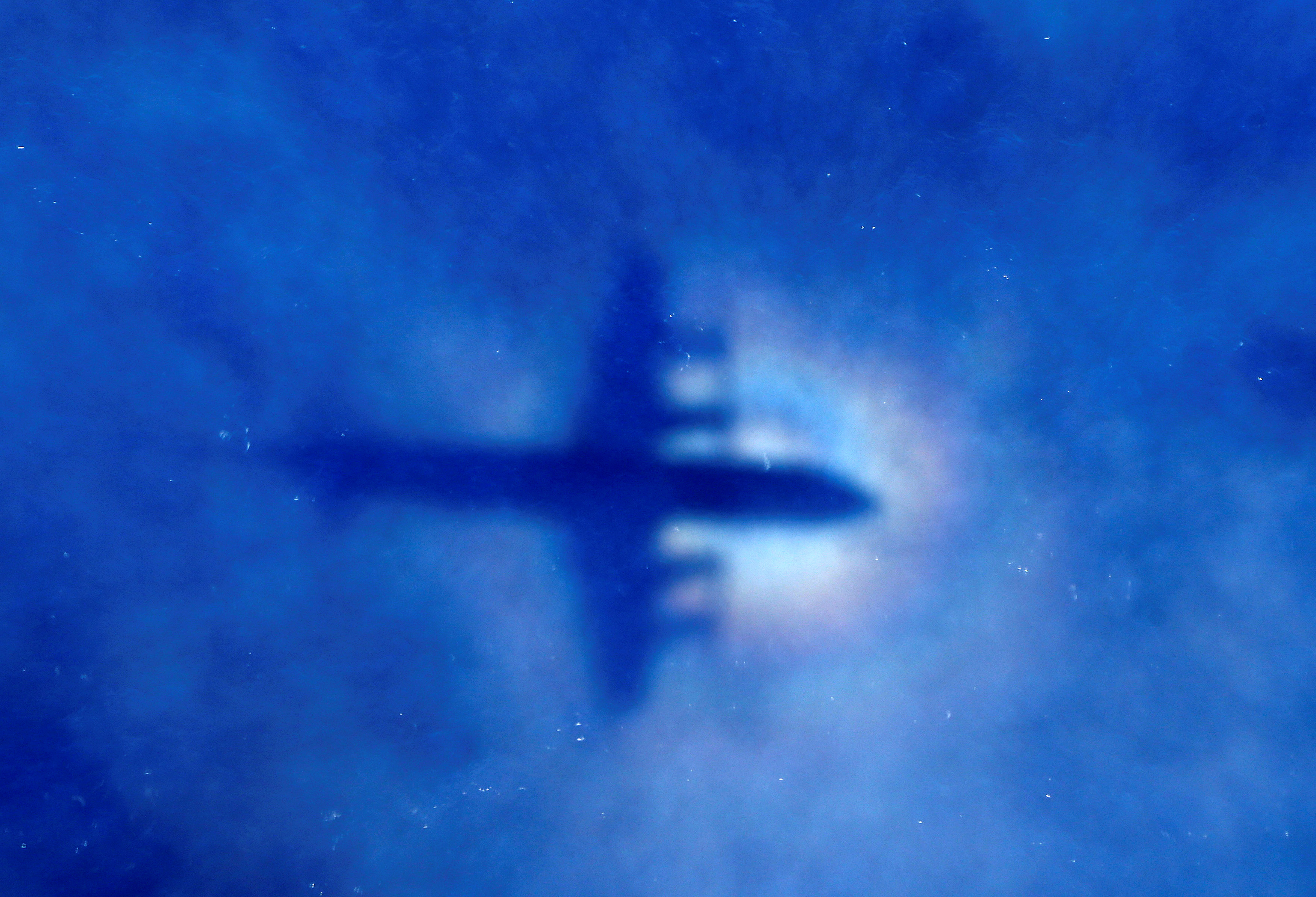 The shadow of a Royal New Zealand Air Force (RNZAF) P3 Orion maritime search aircraft can be seen on low-level clouds as it flies over the southern Indian Ocean looking for missing Malaysian Airlines flight MH370