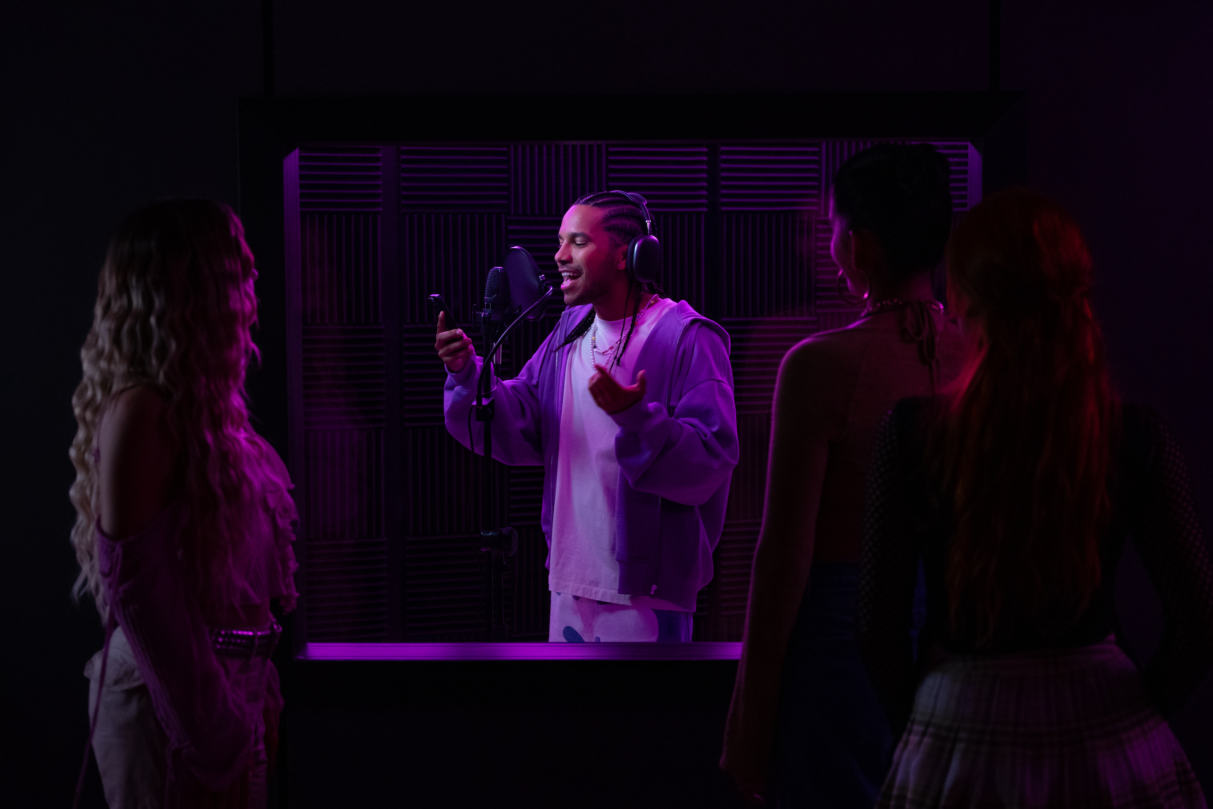 Up-and-coming reggaeton artist Santi (Tyler Dean Flores) records a track in the studio.